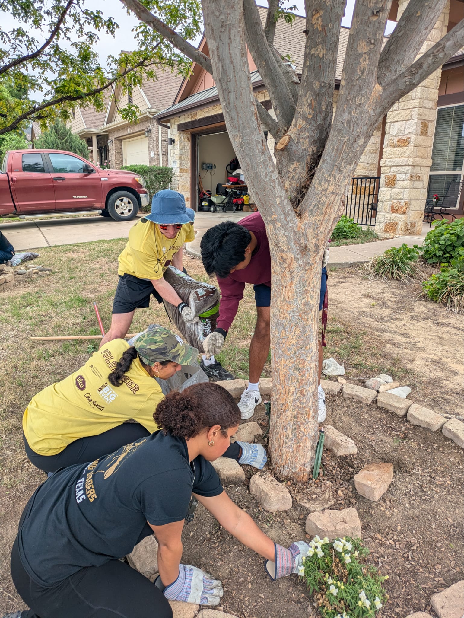 Four McCoy Ambassadors at a Bobcat Build site planting flowers