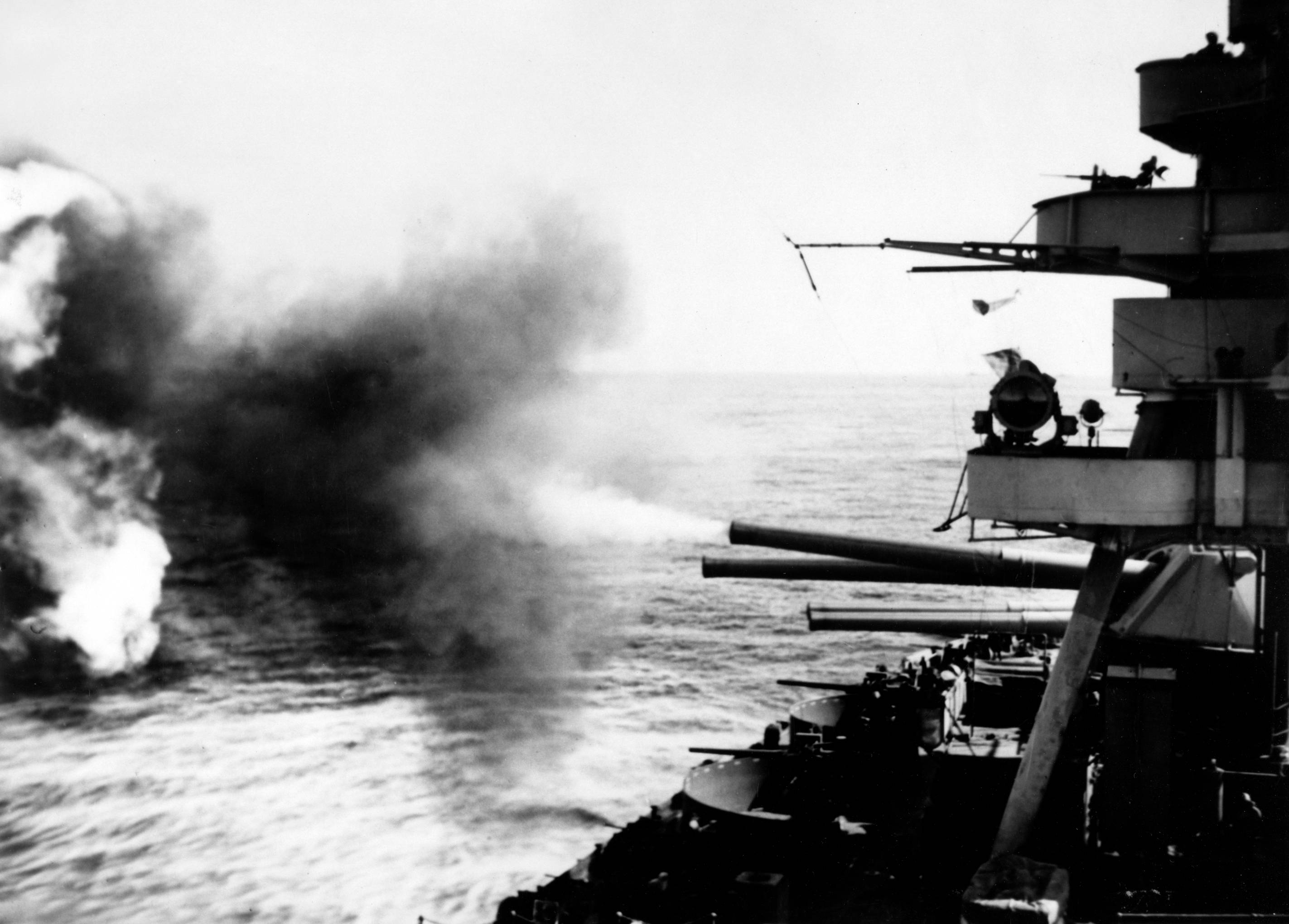 black and white photo from 1945 of U.S.S. New York firing her 14-inch guns during the bombardment of Iwo Jima on February 16, 1945.