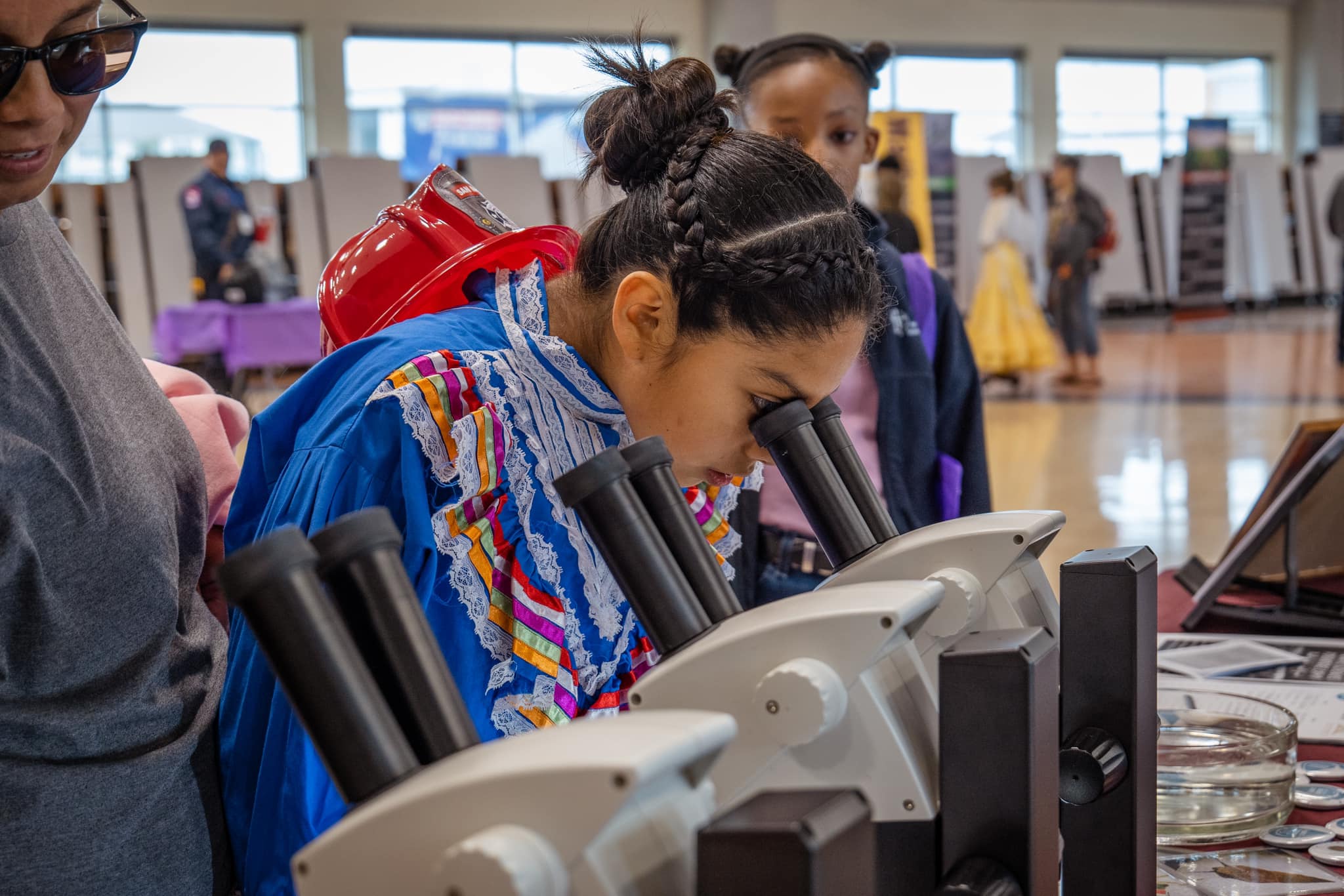 young women looks into microscope