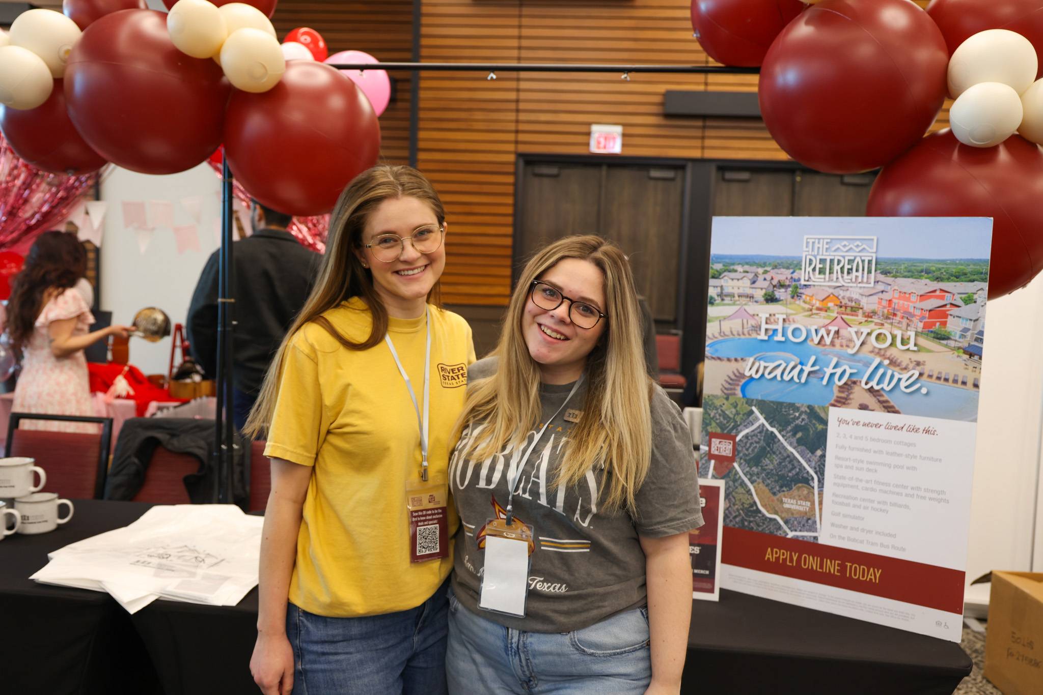 apartment staff assisting students standing at their booth