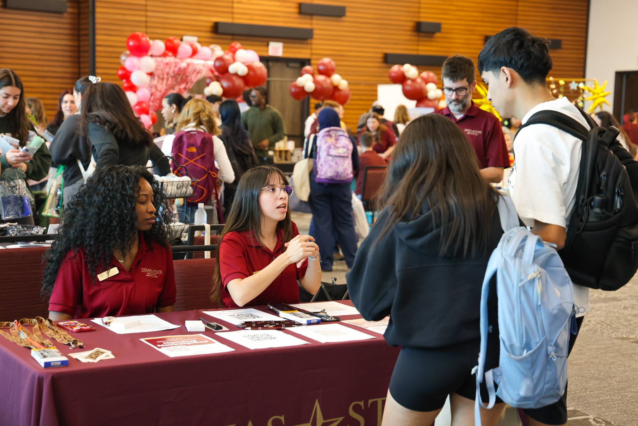 students talking to a table with off-campus living staff