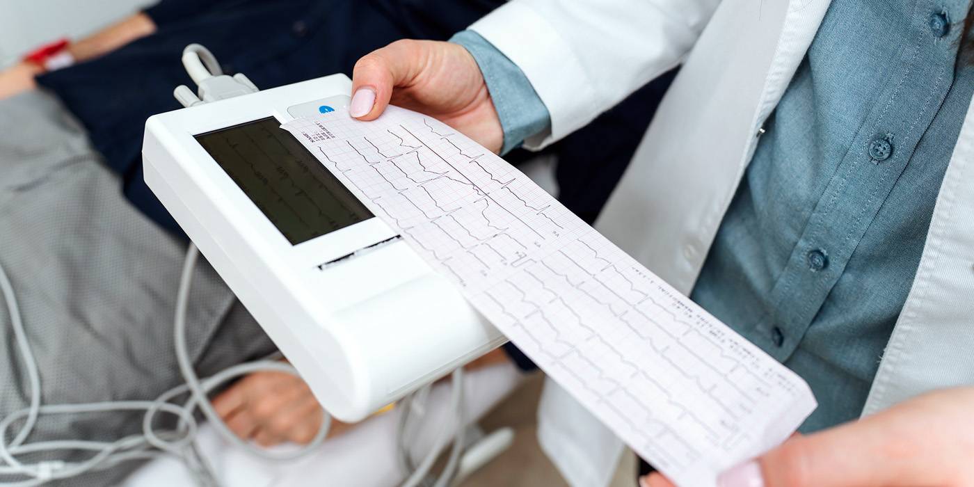 an ekg technician reading a printout
