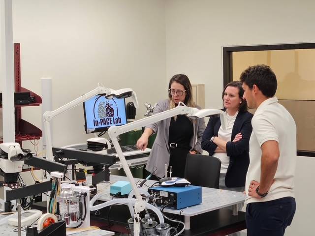 three people looking at lab equipment