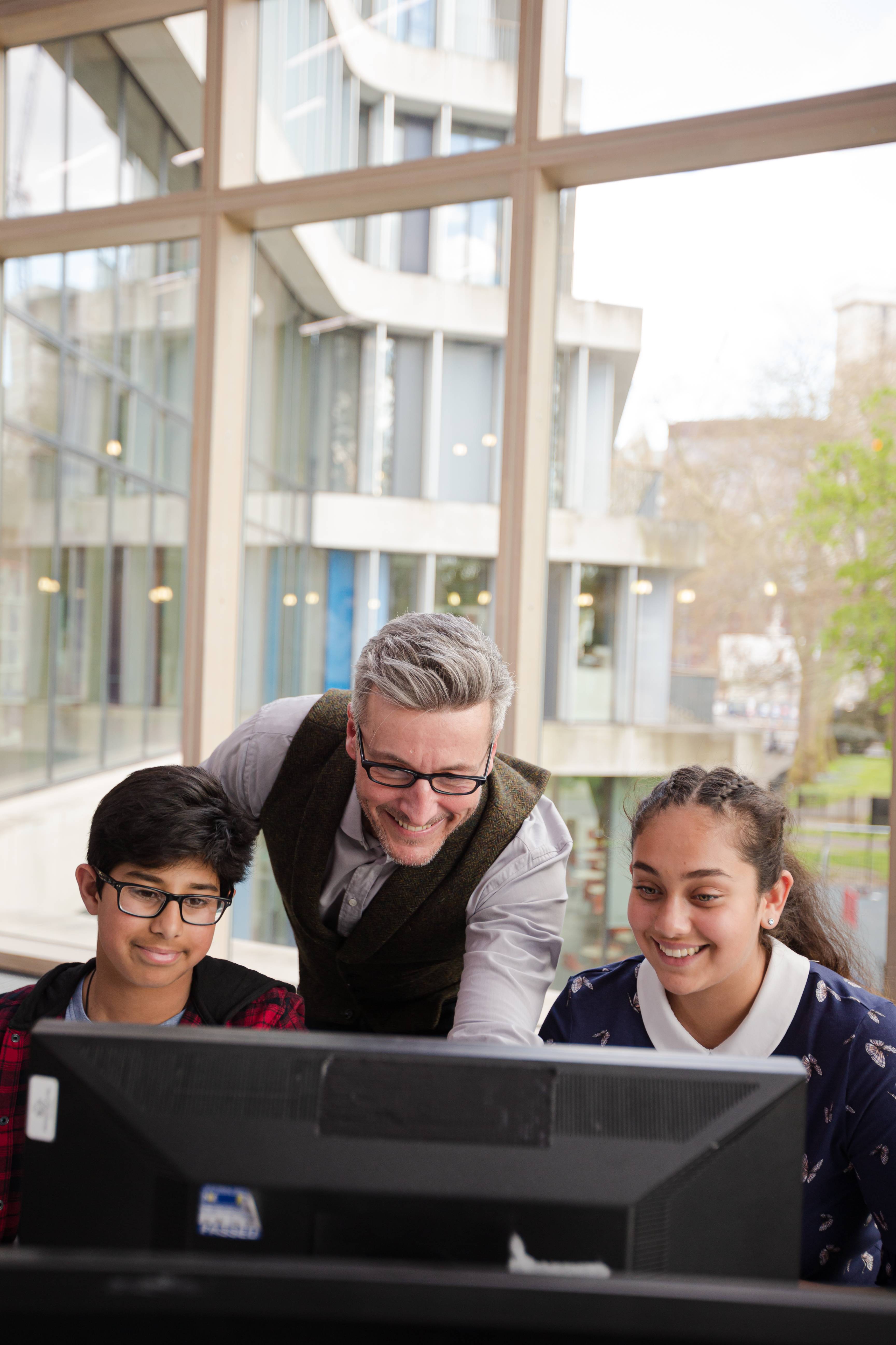 a man and young person learn on a laptop together