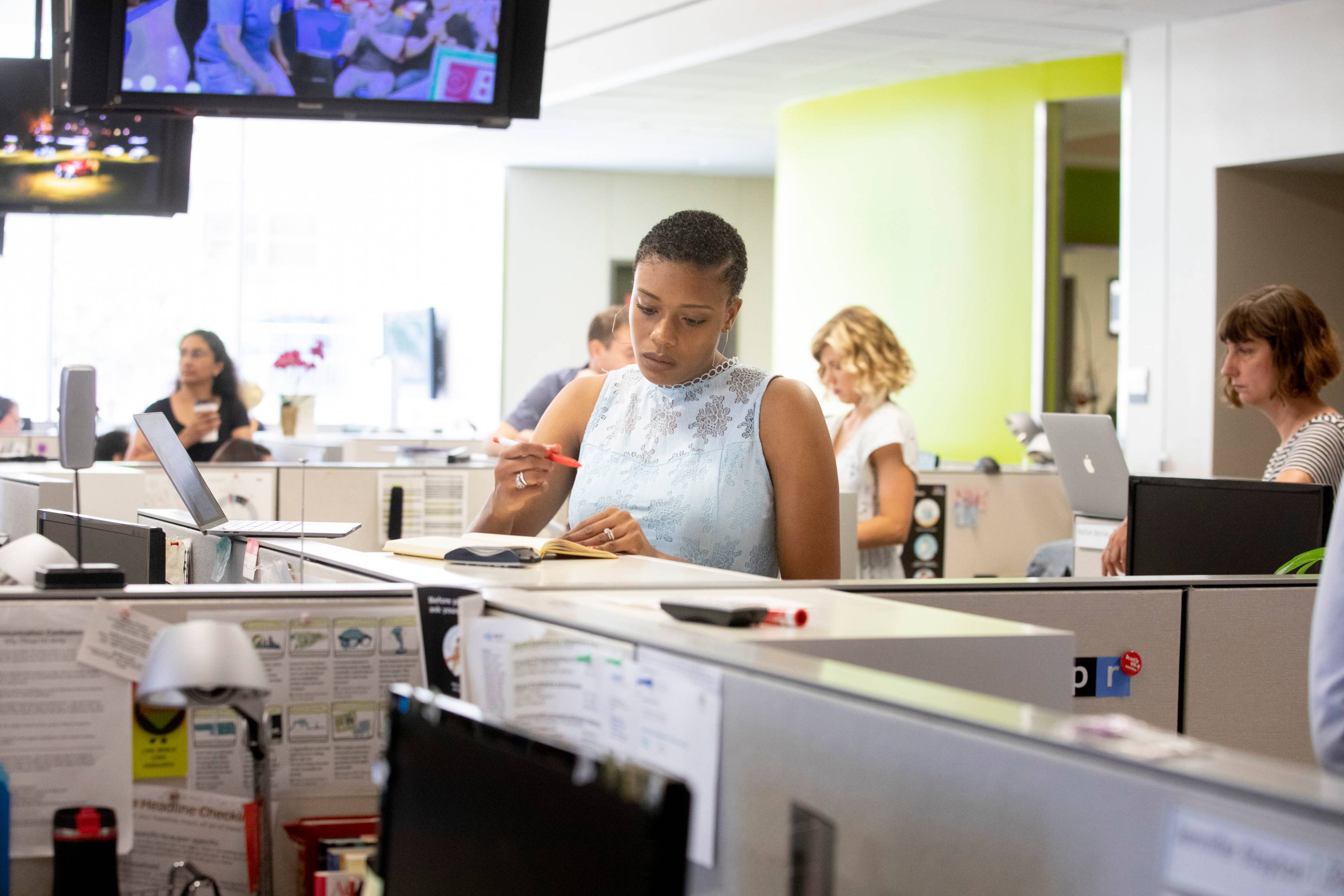 woman writing at press desk