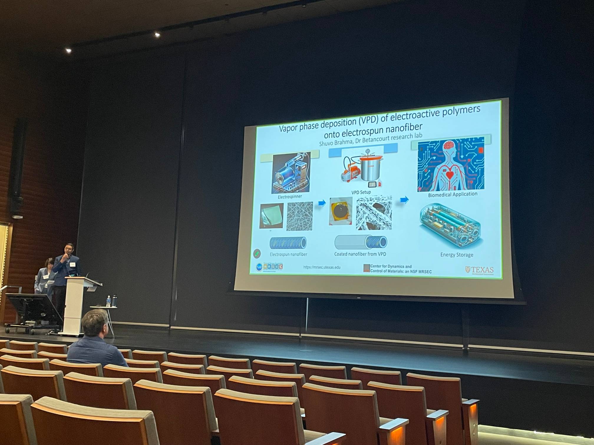 PREM student presenting research at stage of  UT MRSEC Annual Meeting Industry Day