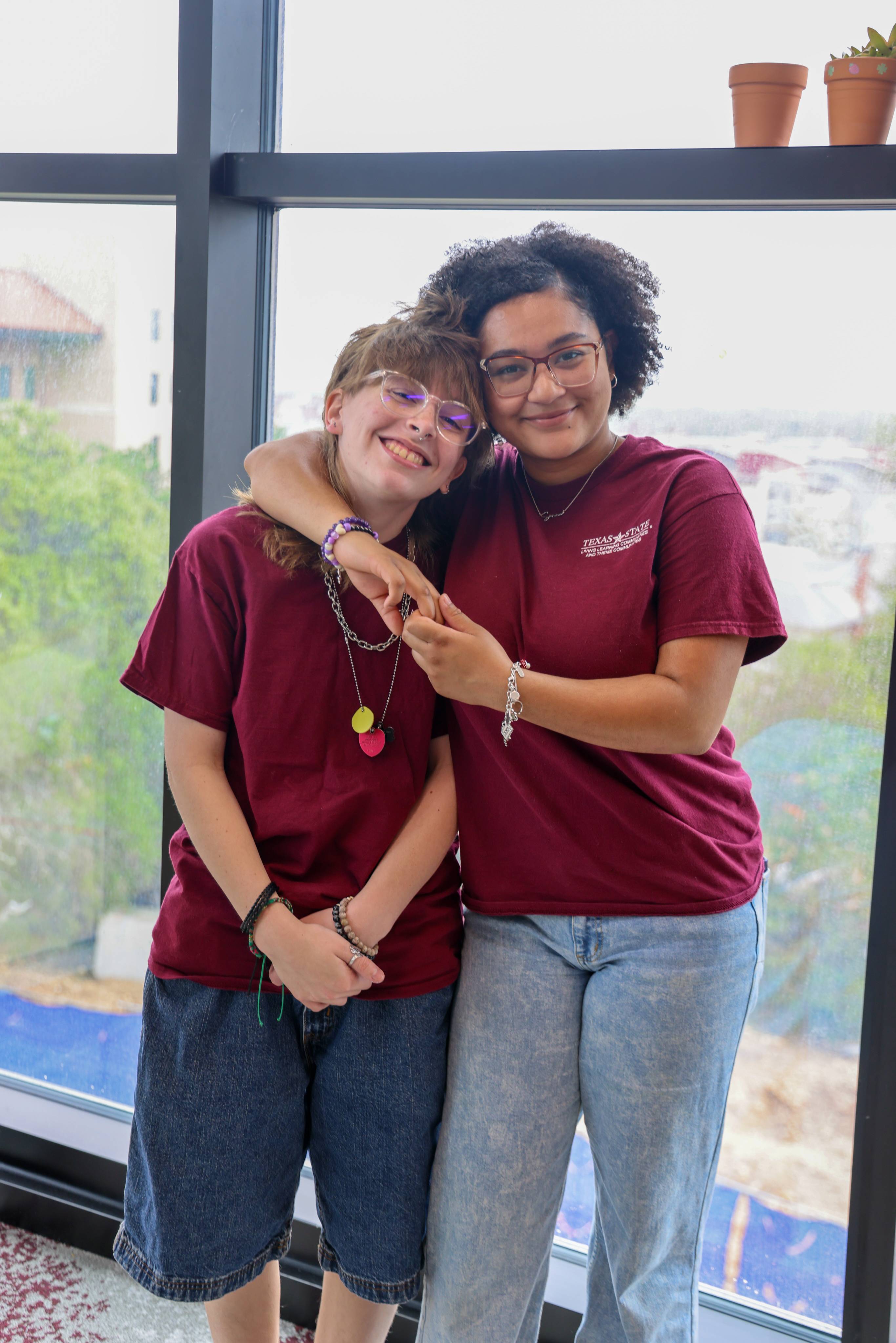 Two students standing arm in arm