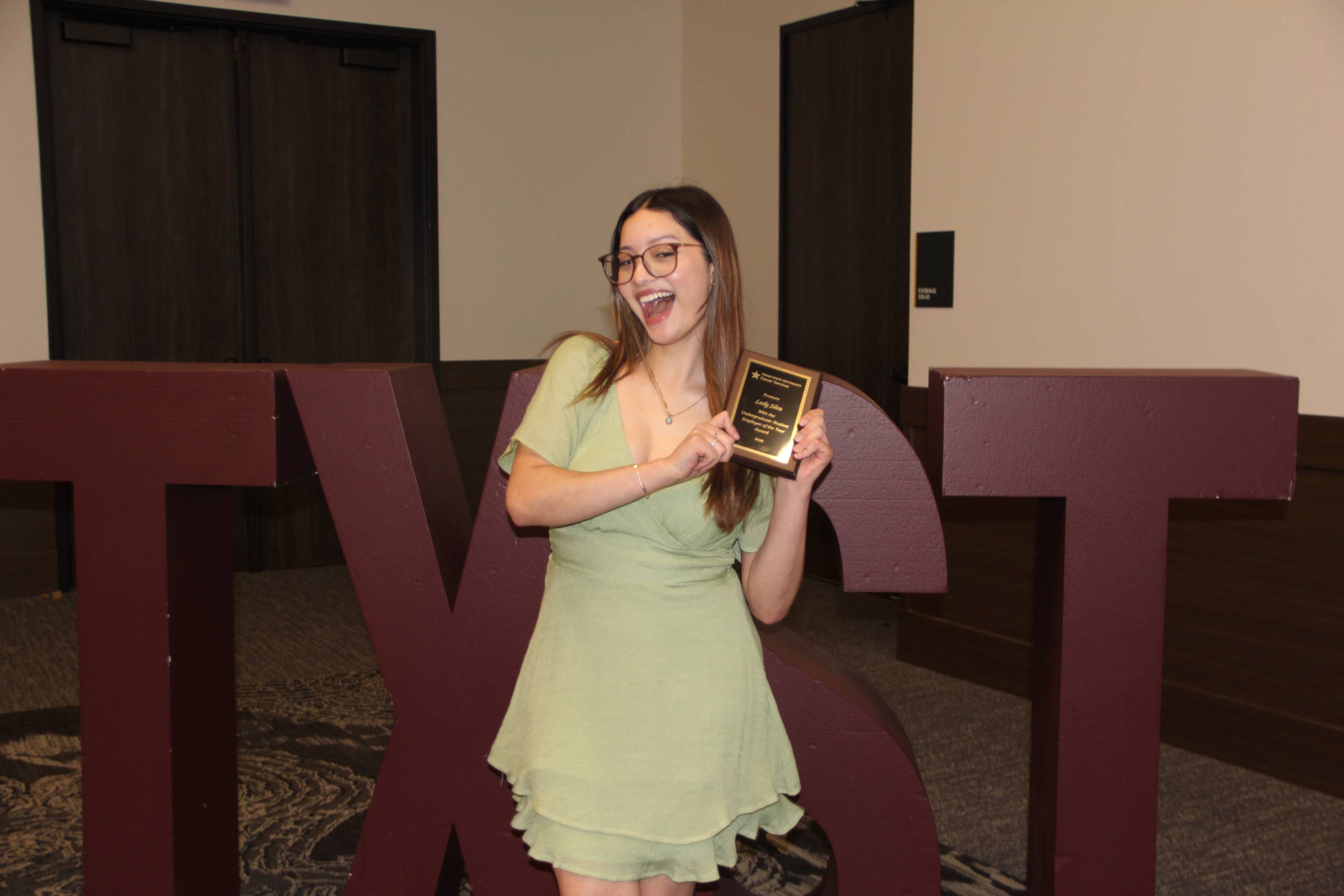 Lesly posing with her award