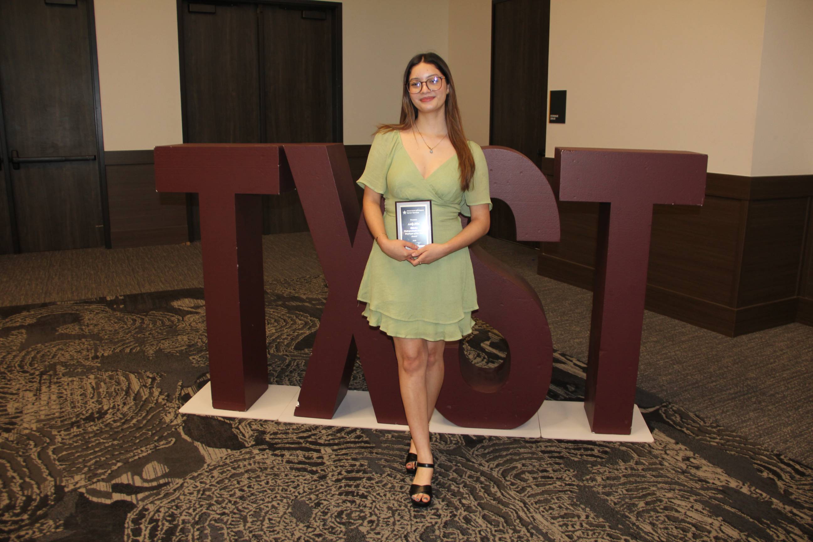 Lesly posing with her award.