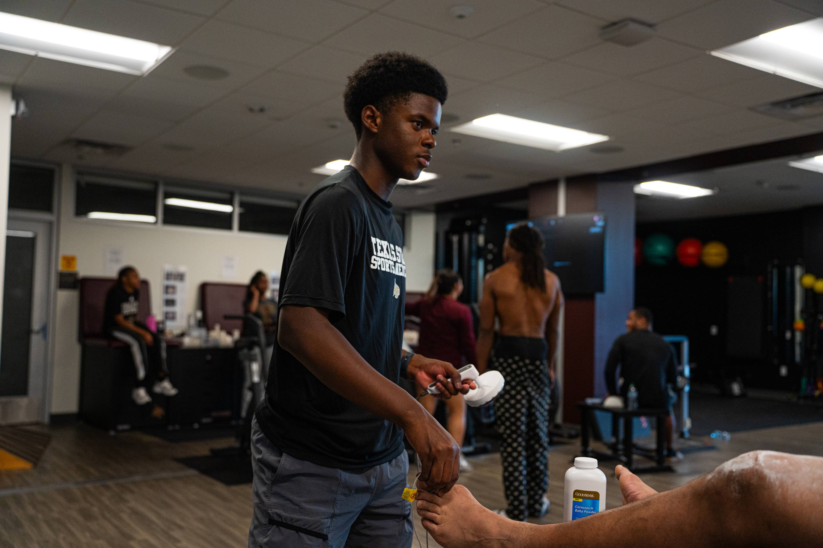 football player gets worked on by athletic trainer