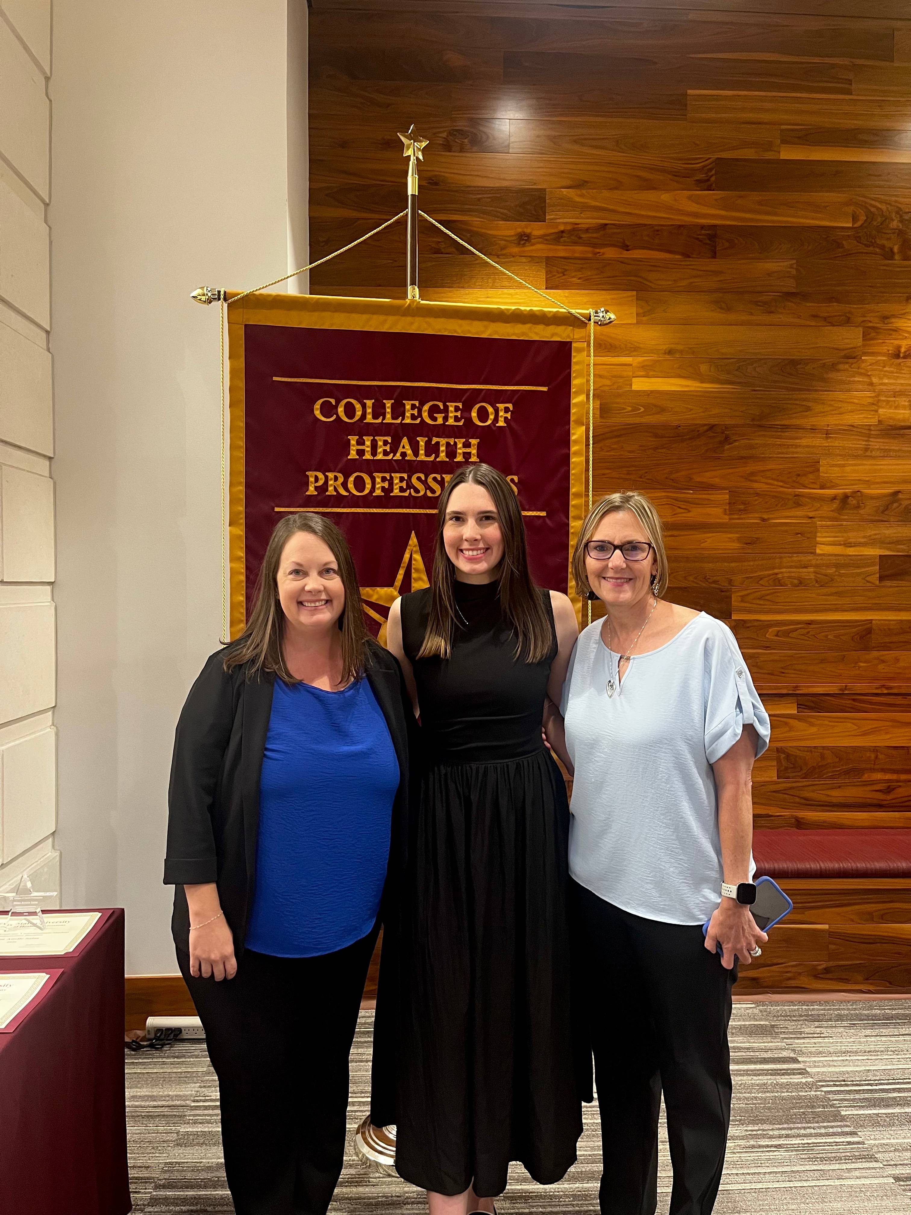 Ms. Baccinelli standing next to her mom and next to Associate Professor of Instruction, Ms. Bowers.