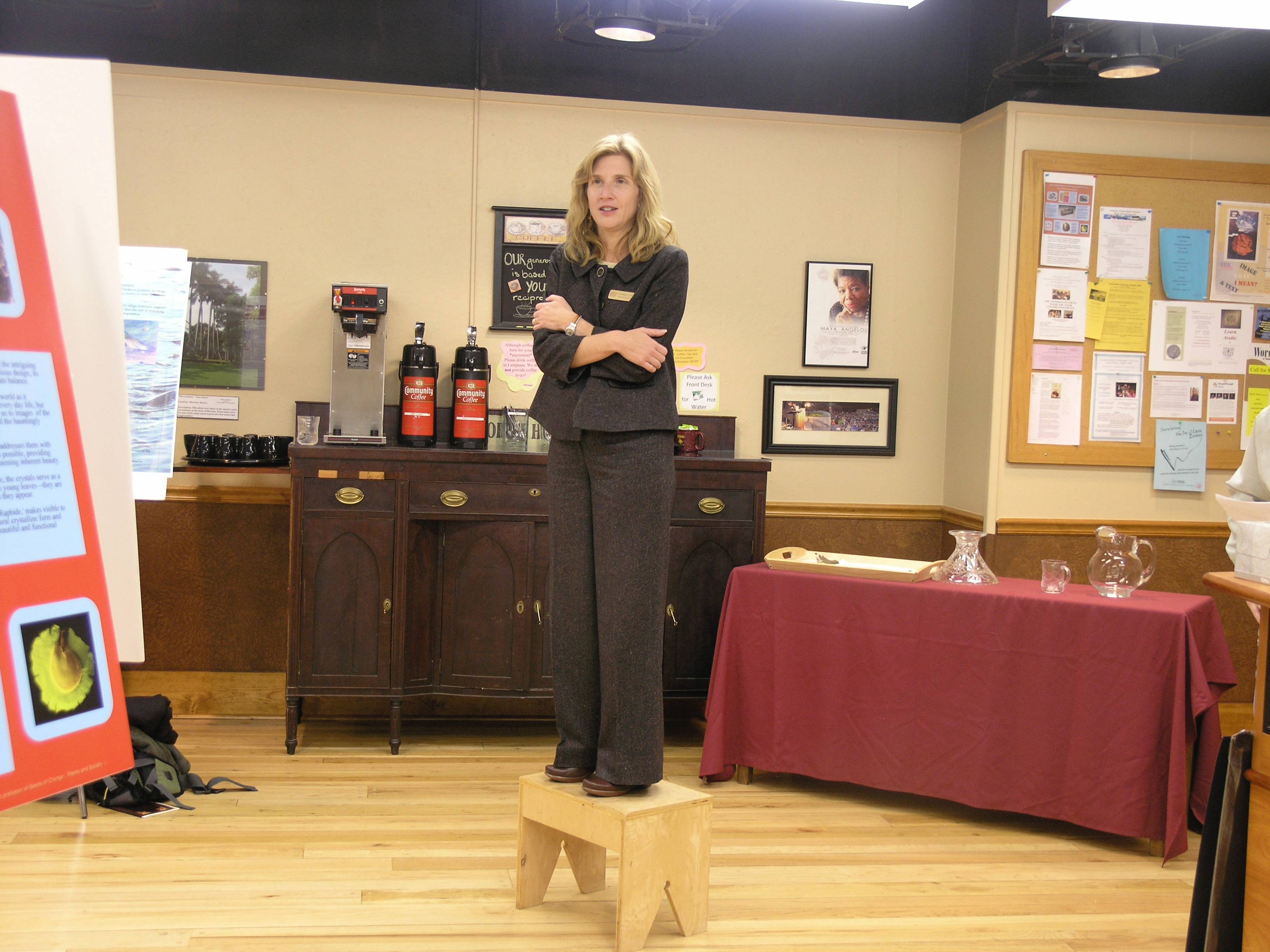 woman standing on small wooden stool with her arms crossed
