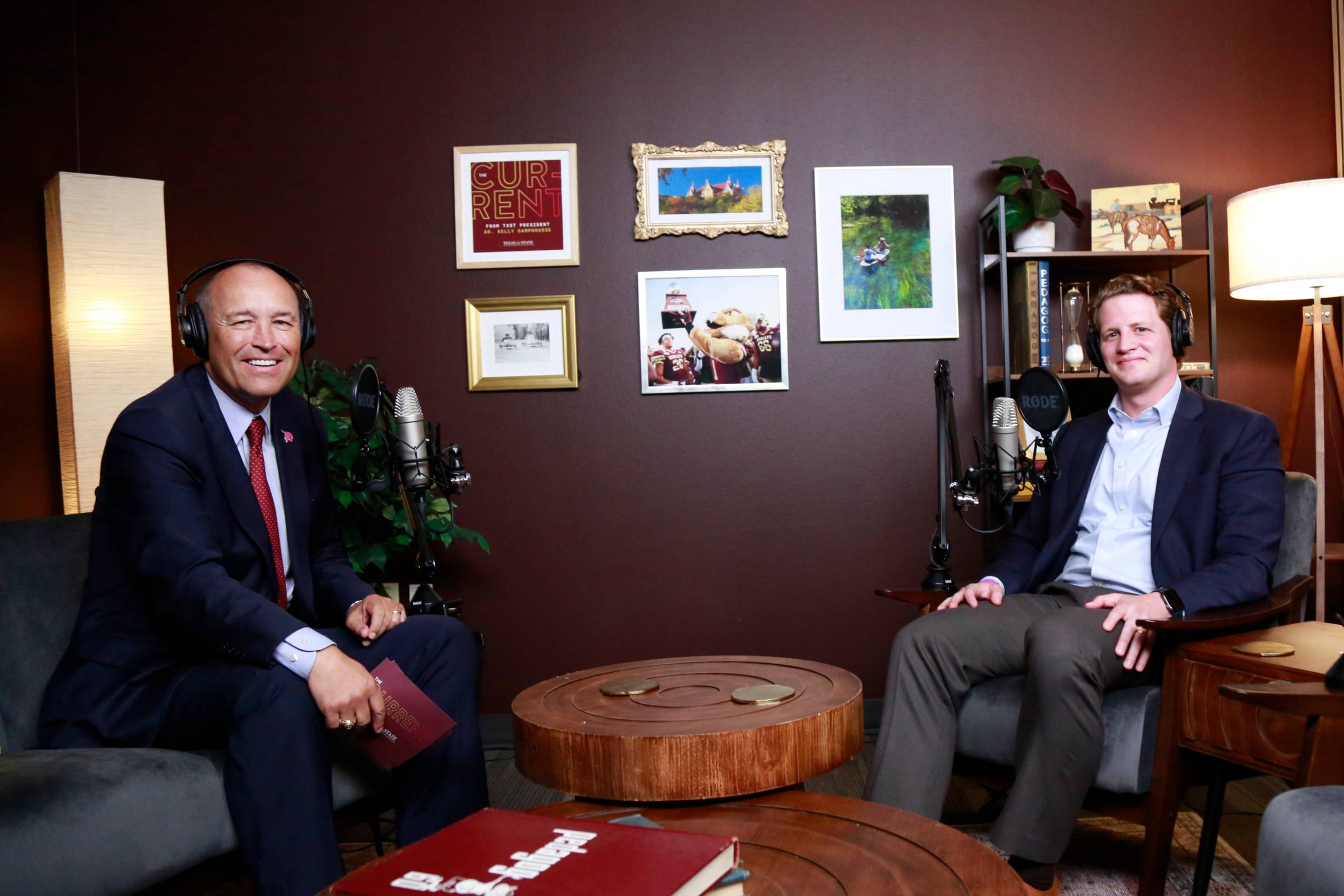 president kelly damphousse and nathan mcdaniel seated in chairs while wearing headphones
