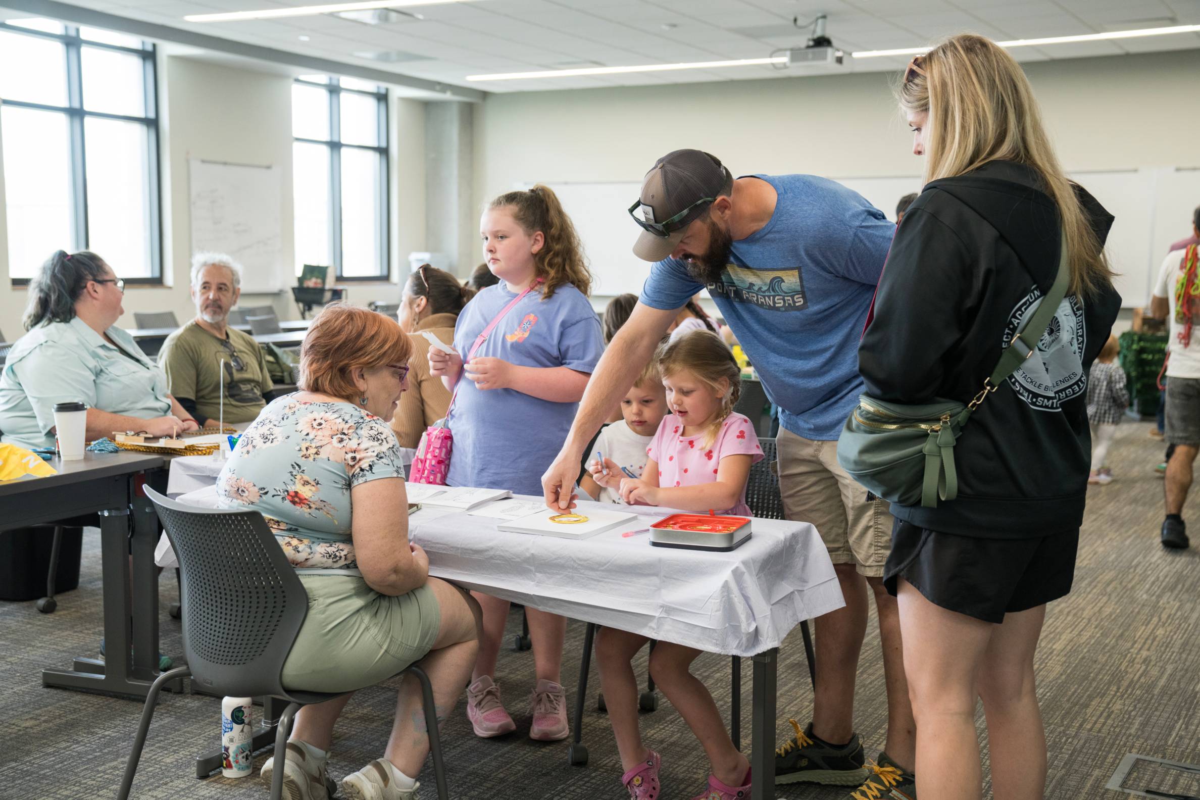 family sitting at table and coloring at community event