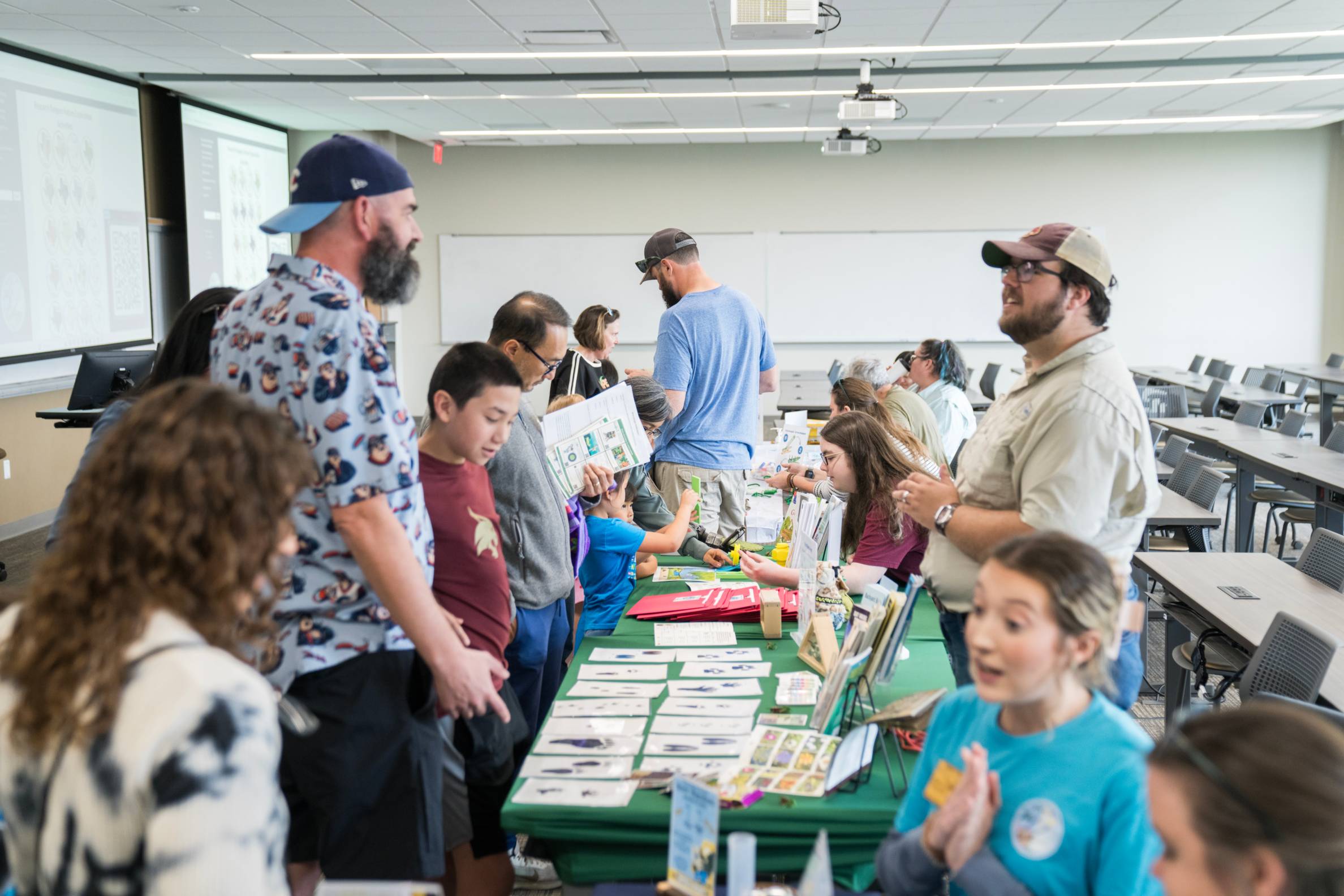 multiple people looking at different tables at community event