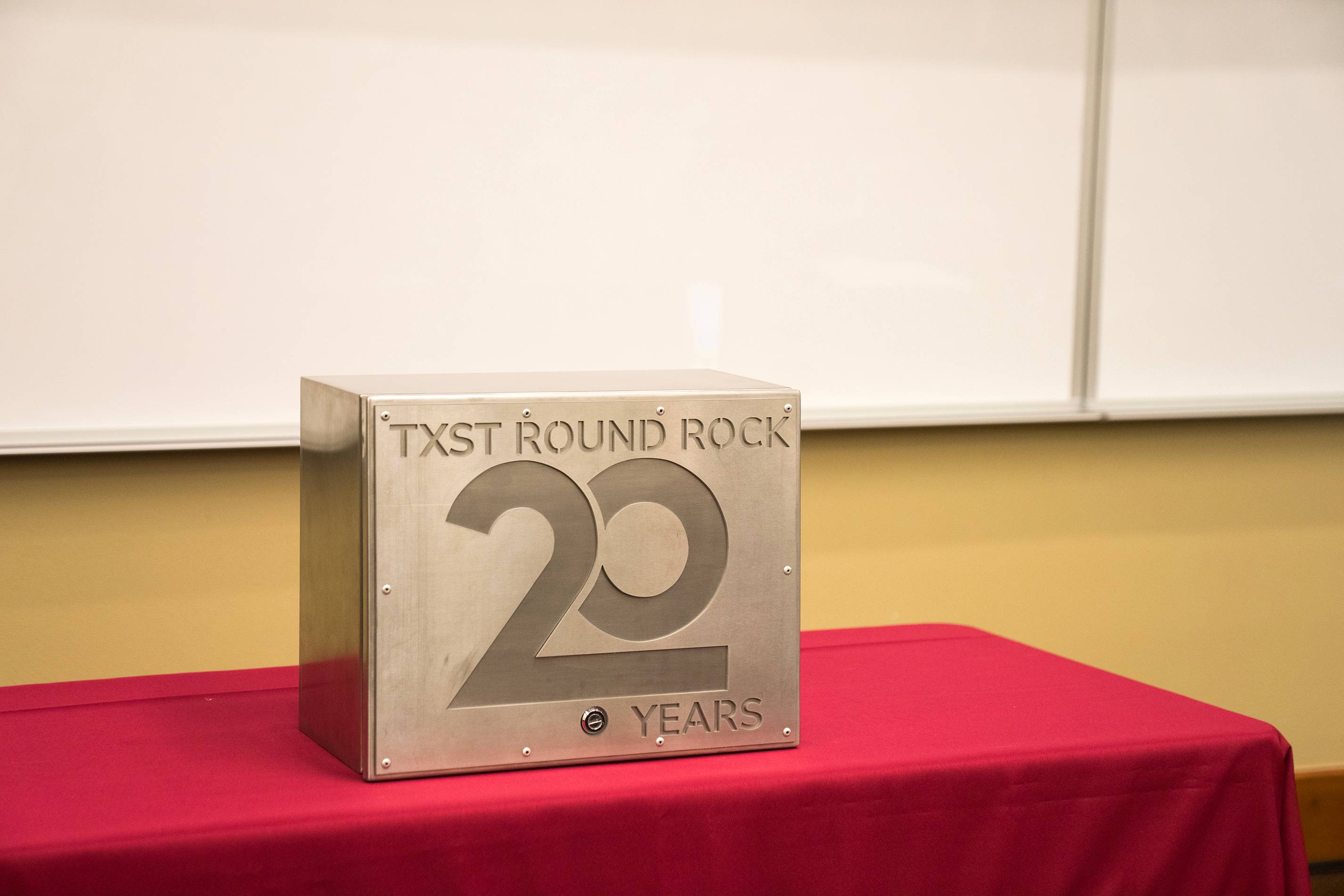 large metal box with "TXST Round Rock 20 Years"