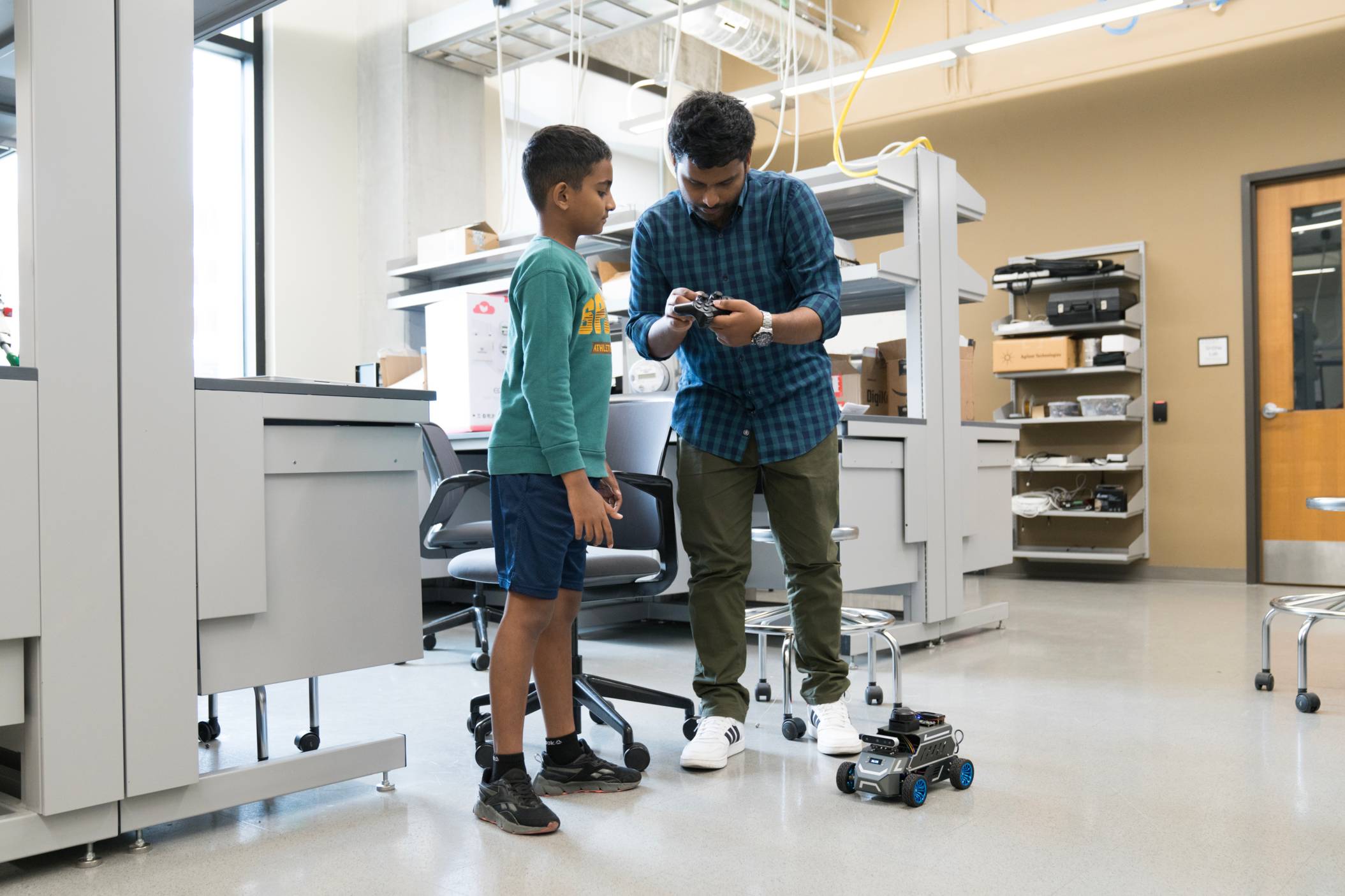 man shows off robotics to young child