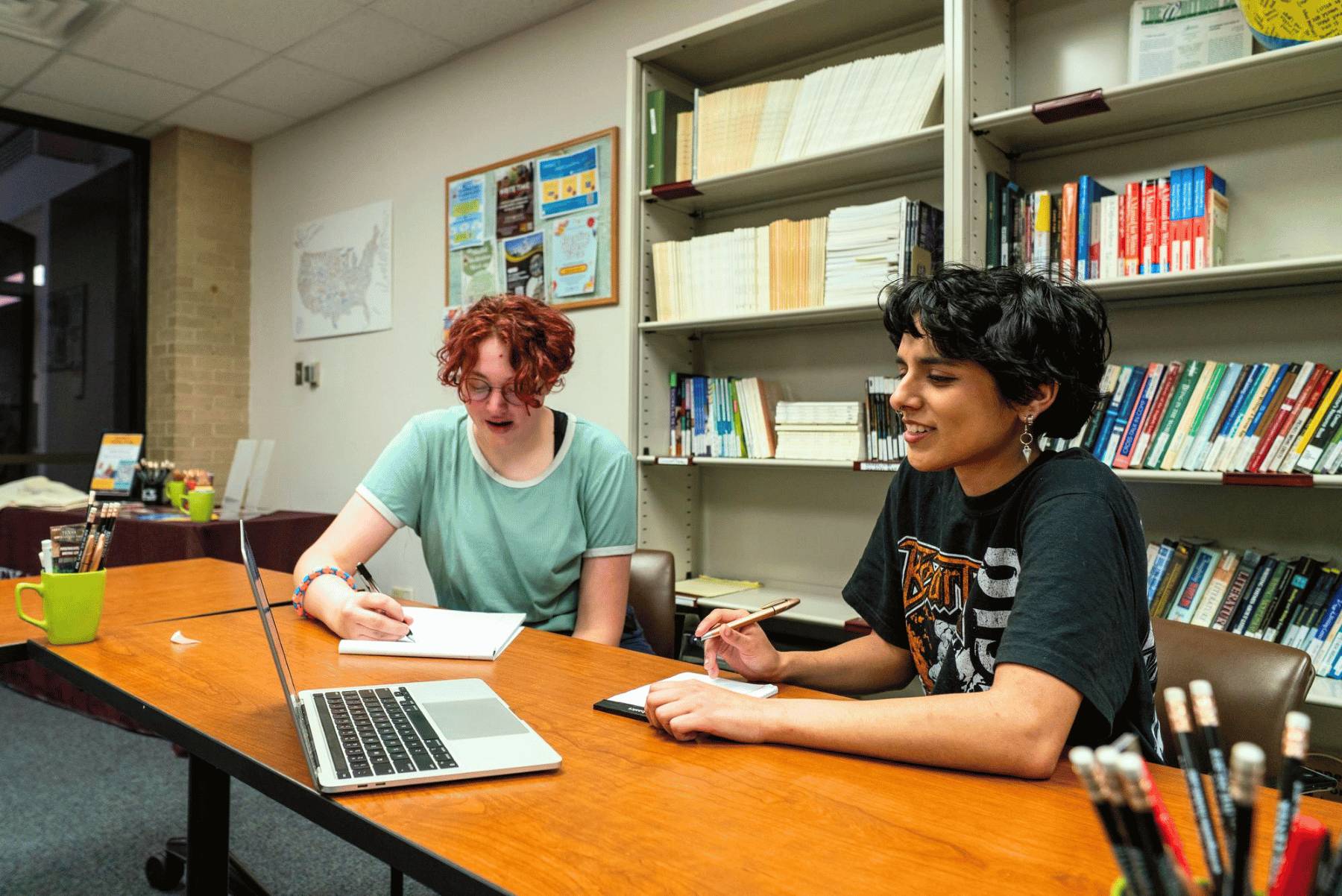 Two students working from a laptop.
