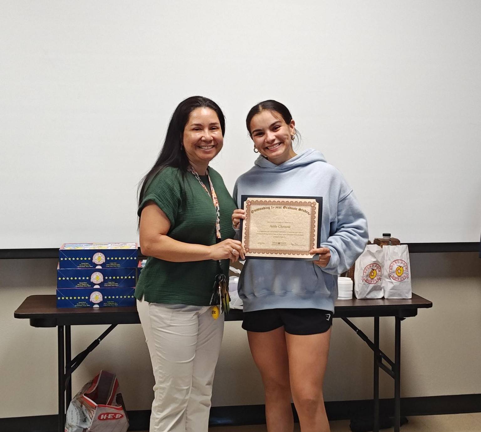 Year 1 Graduate Student is receiving a diploma from the hands of Dr. Maria Resendiz
