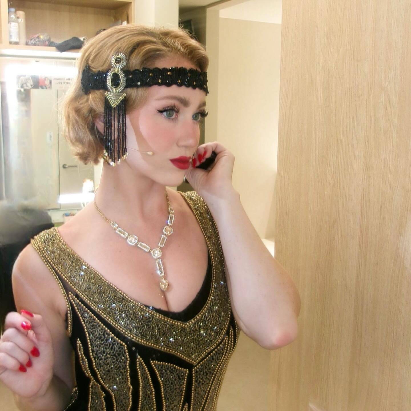 woman wearing a costume from the 1920's looking into the mirror