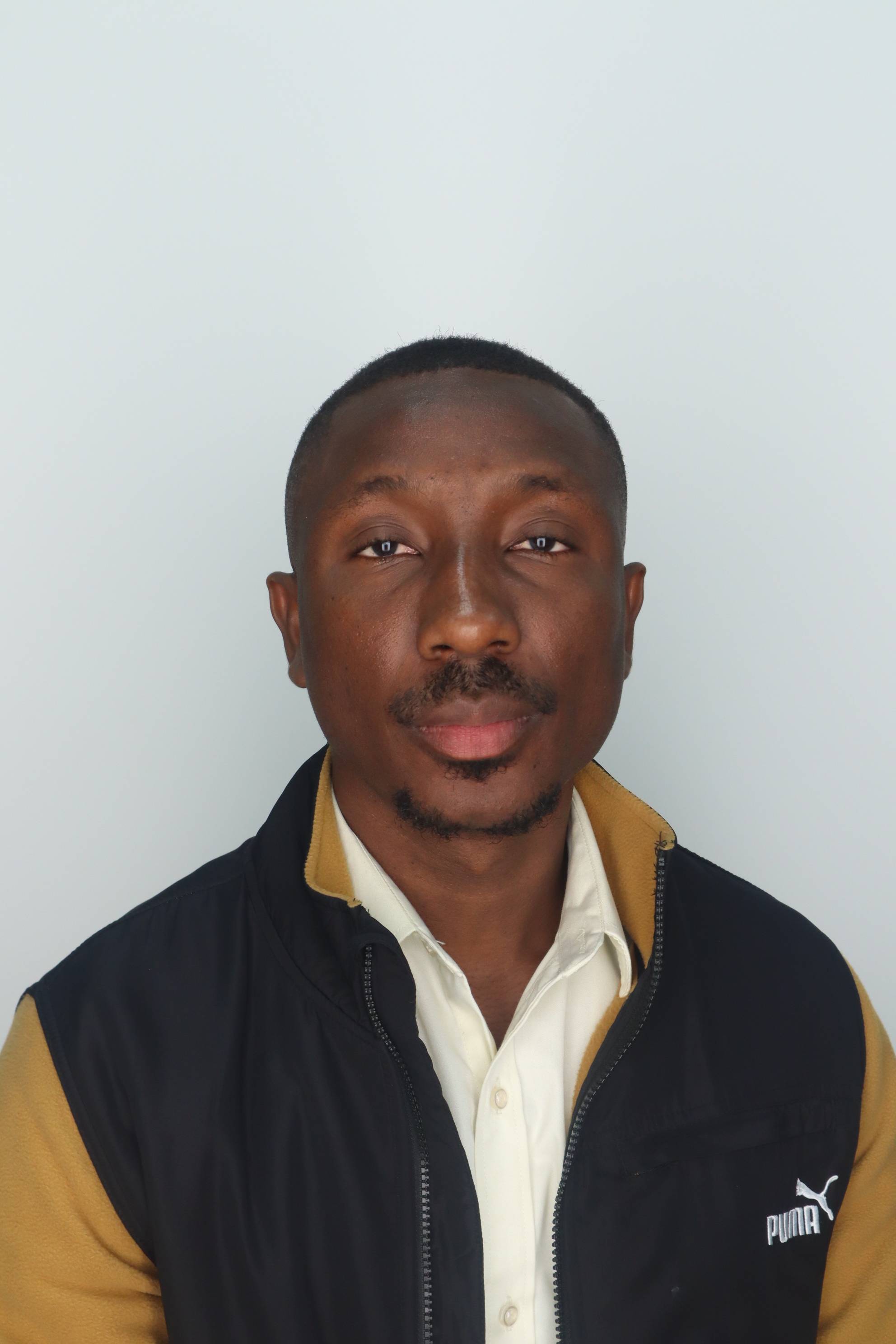 young african american man wearing a black vest and looking at camera