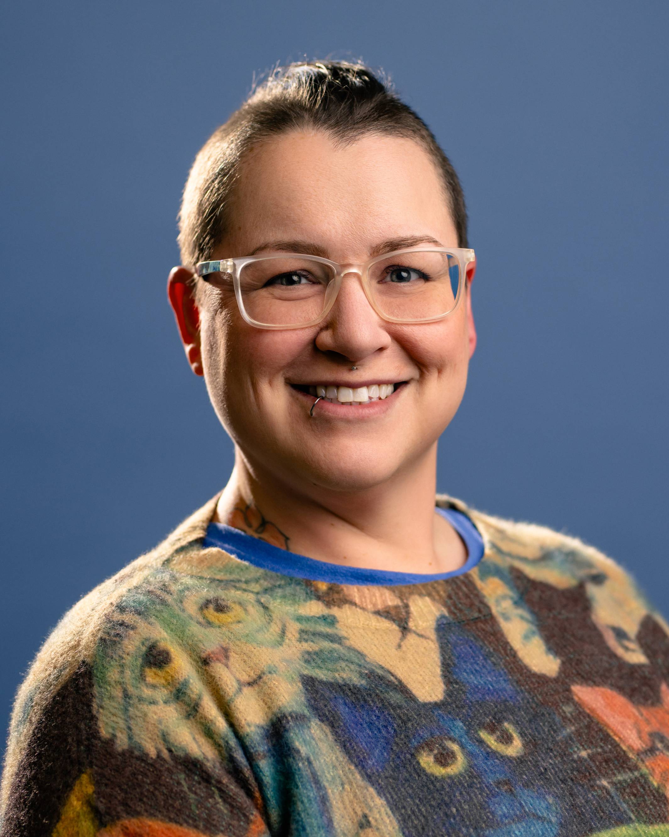 female with glasses smiling at camera