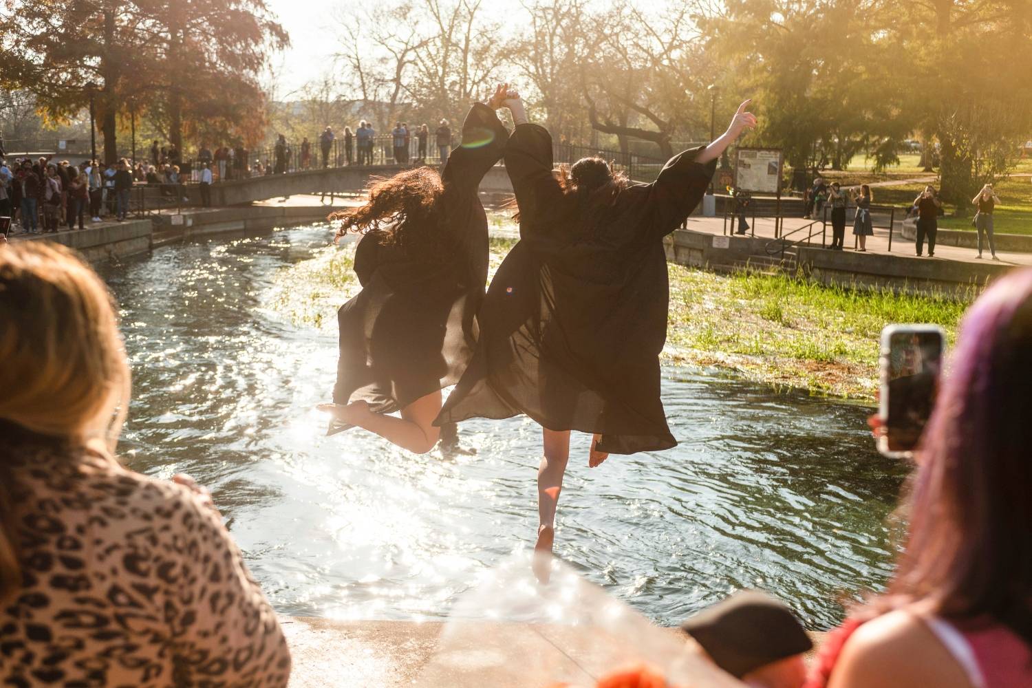 Two students jumping into the water in Sewell park 