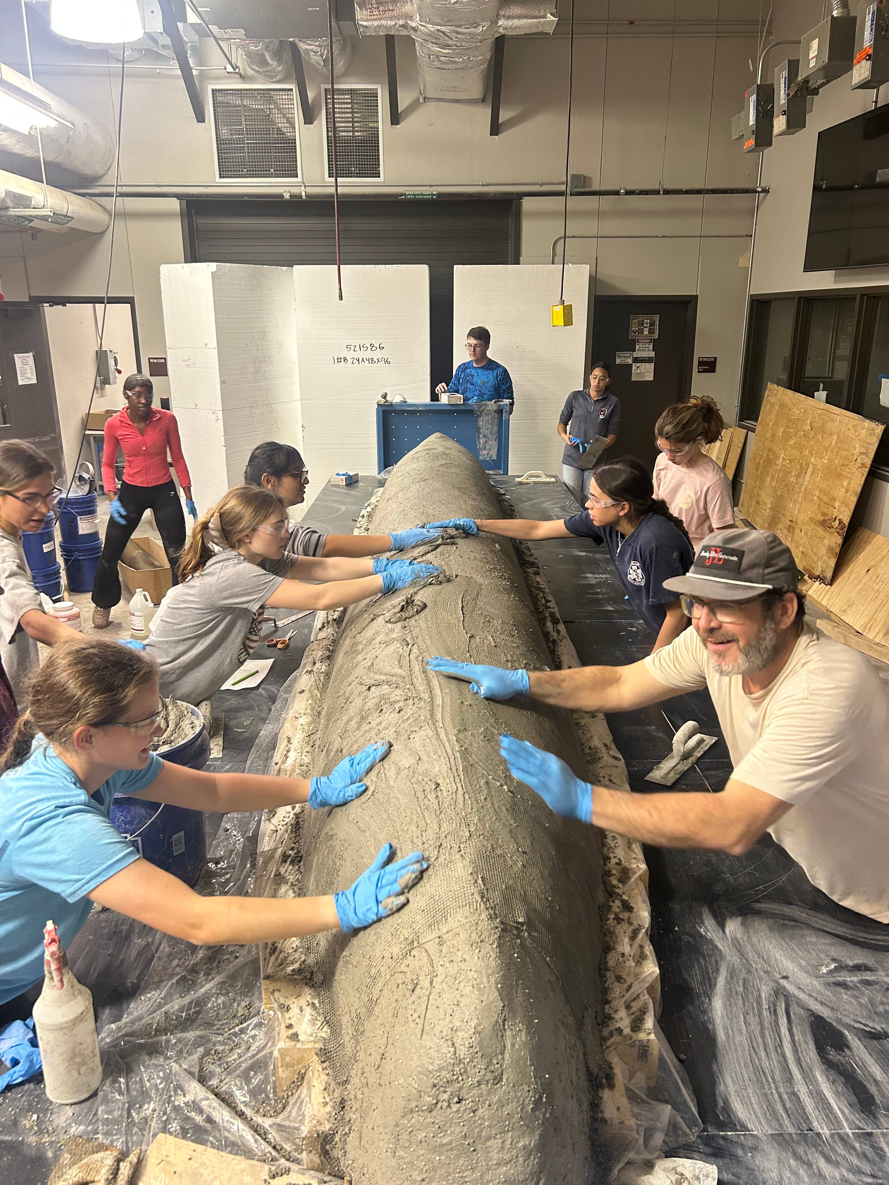 students pouring concrete canoe