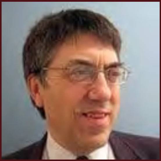 Dr. Seidman wearing glasses and suit against light background