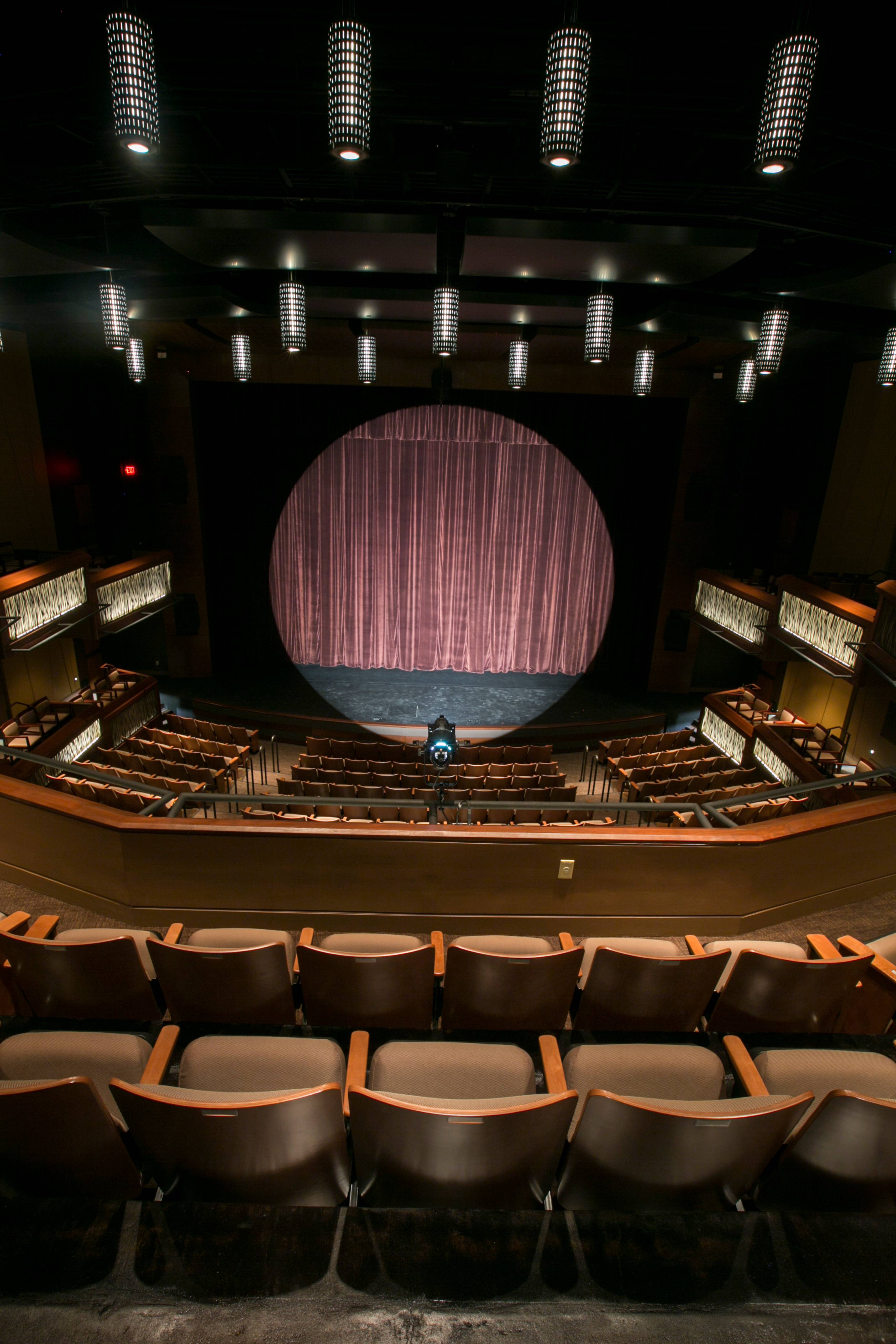 a light is centered on stage at the performing arts center