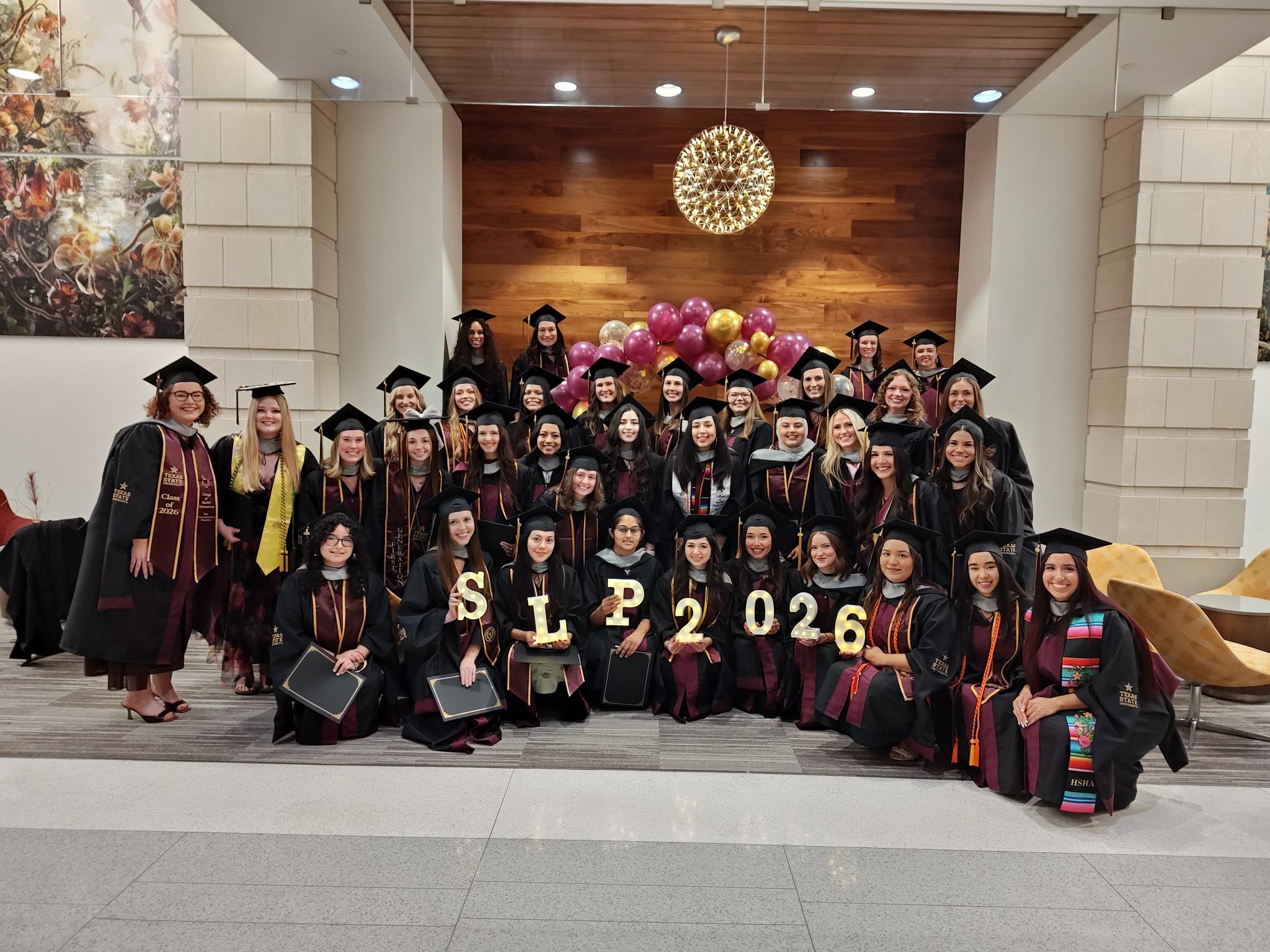 Group picture of the CDIS Graduate Class of 2026 in the lower level of the Willow Hall building in the Round Rock campus.