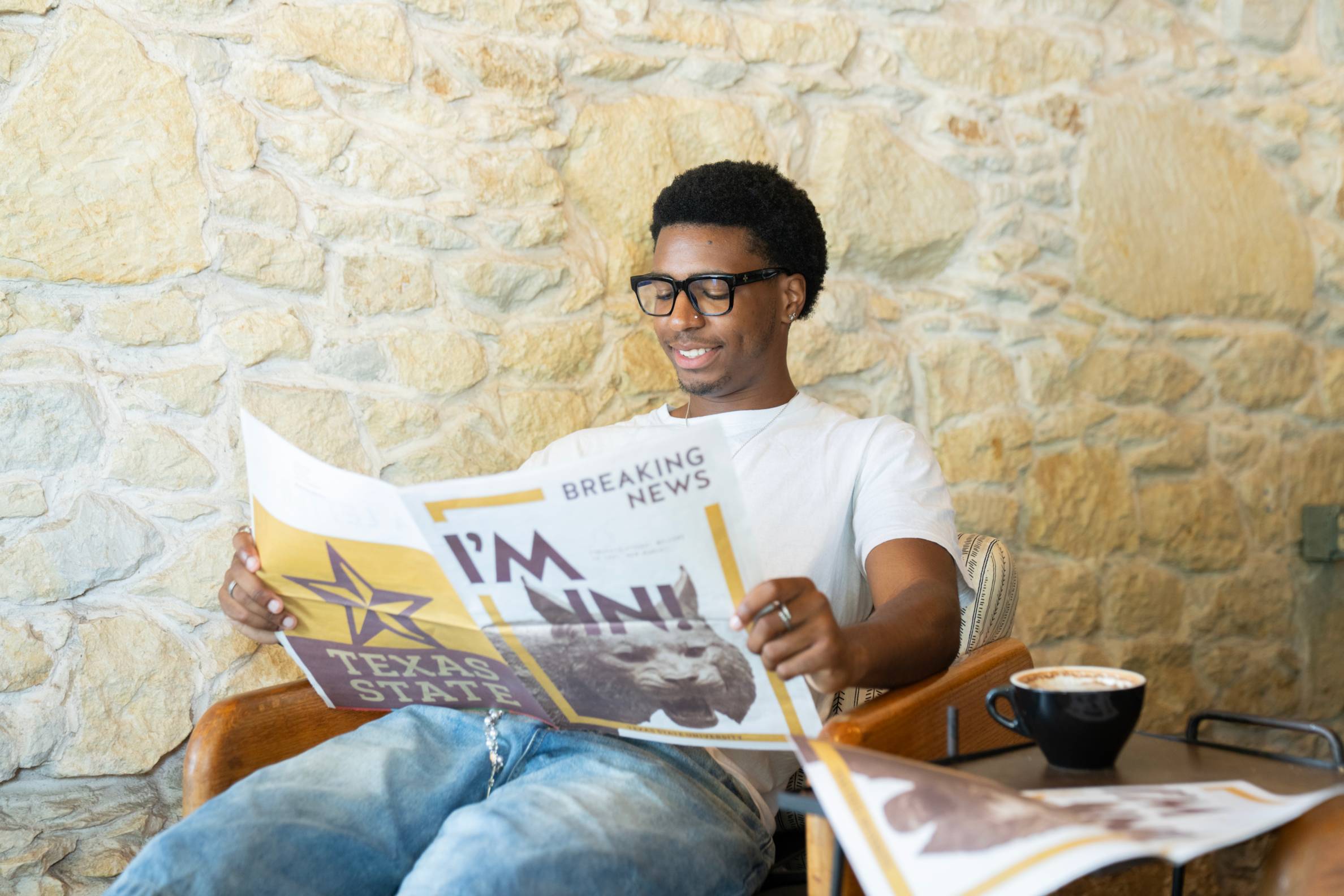 Man sitting down reading a newspaper that reads "I'm in!"