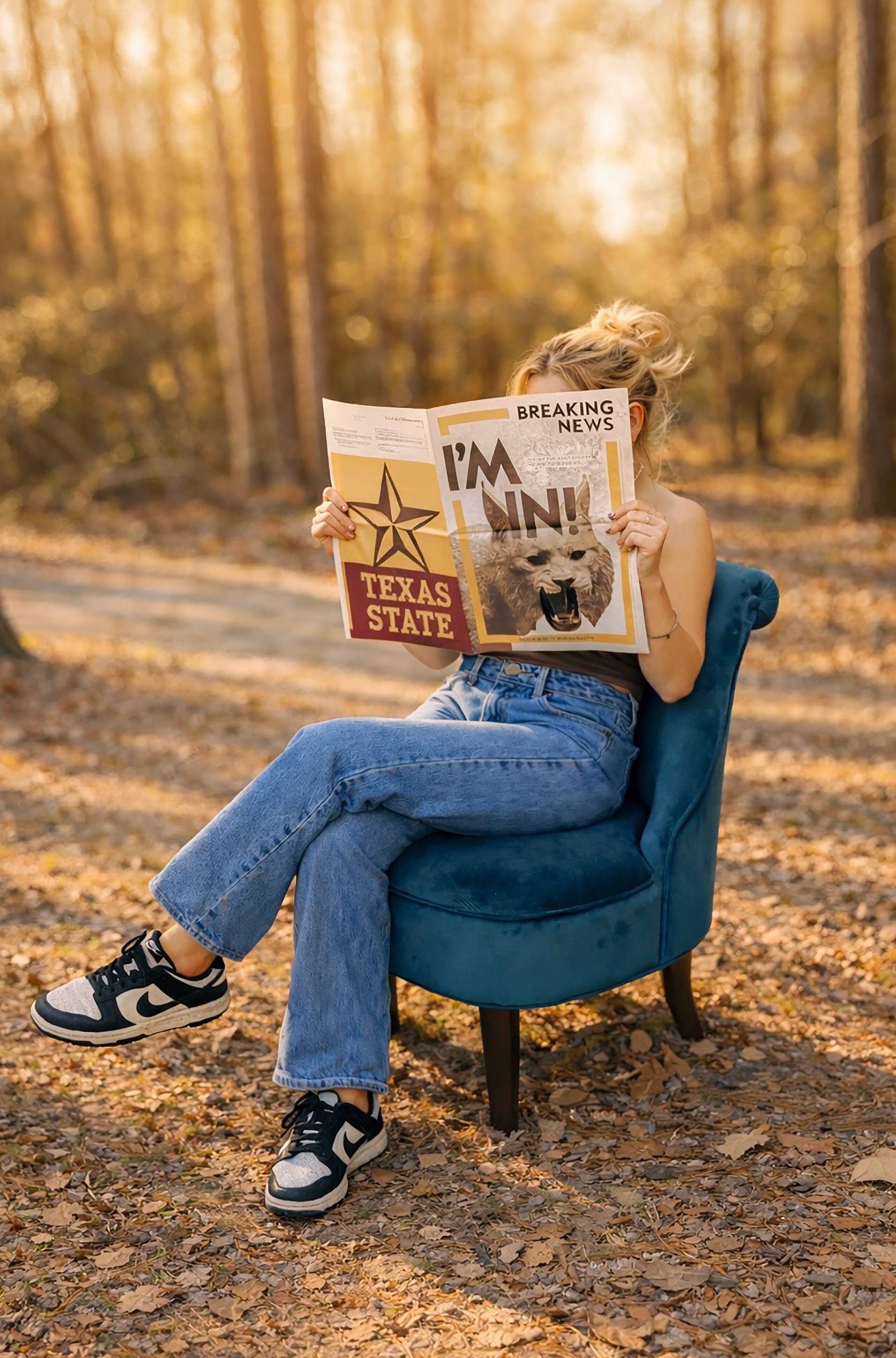 woman in blue chair sitting with newspaper covering face that reads "I'M IN!"