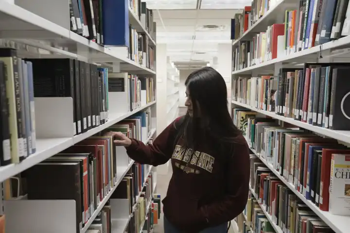 student looking for a book in the book racks