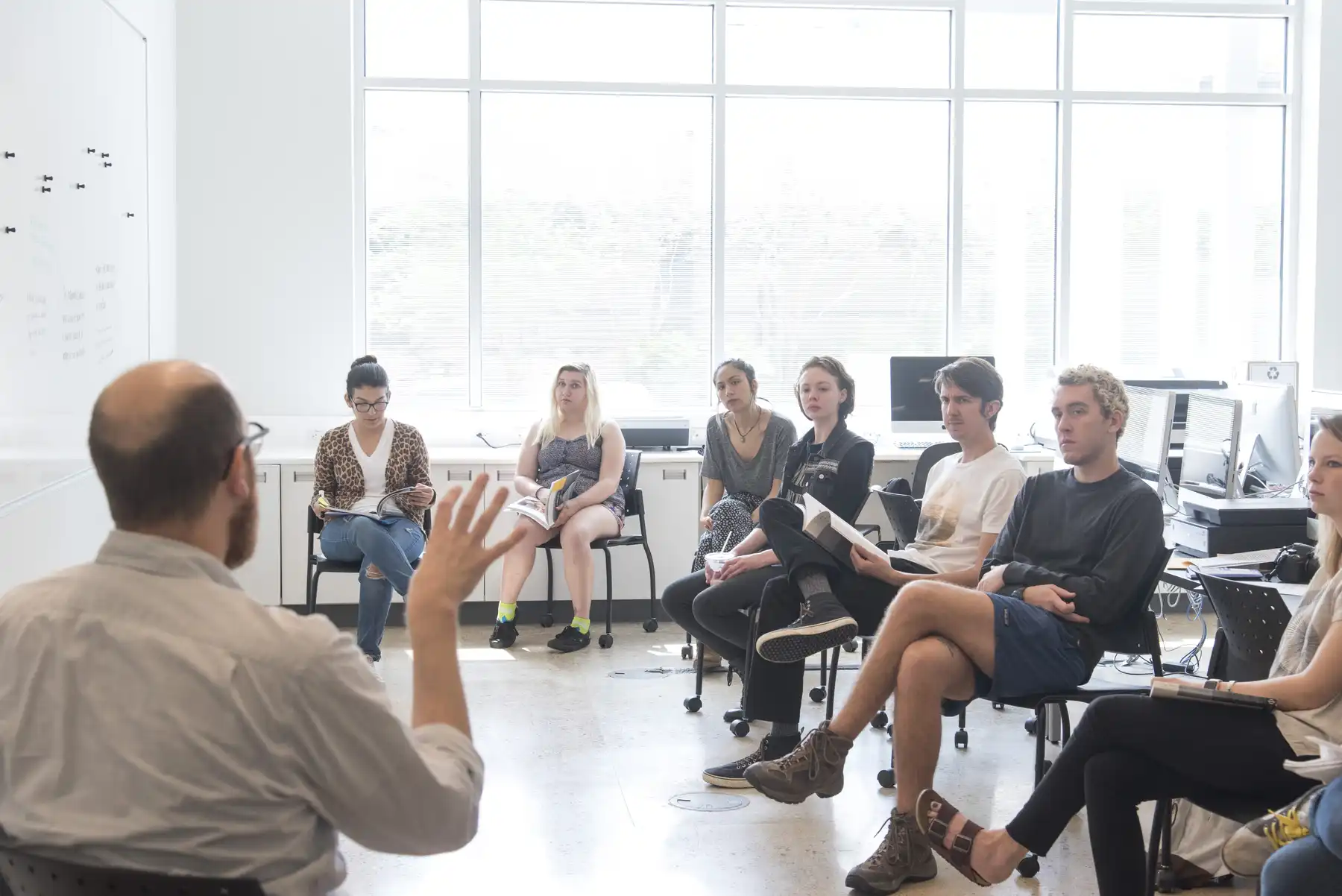 faculty with a group of students participating in a group discussion