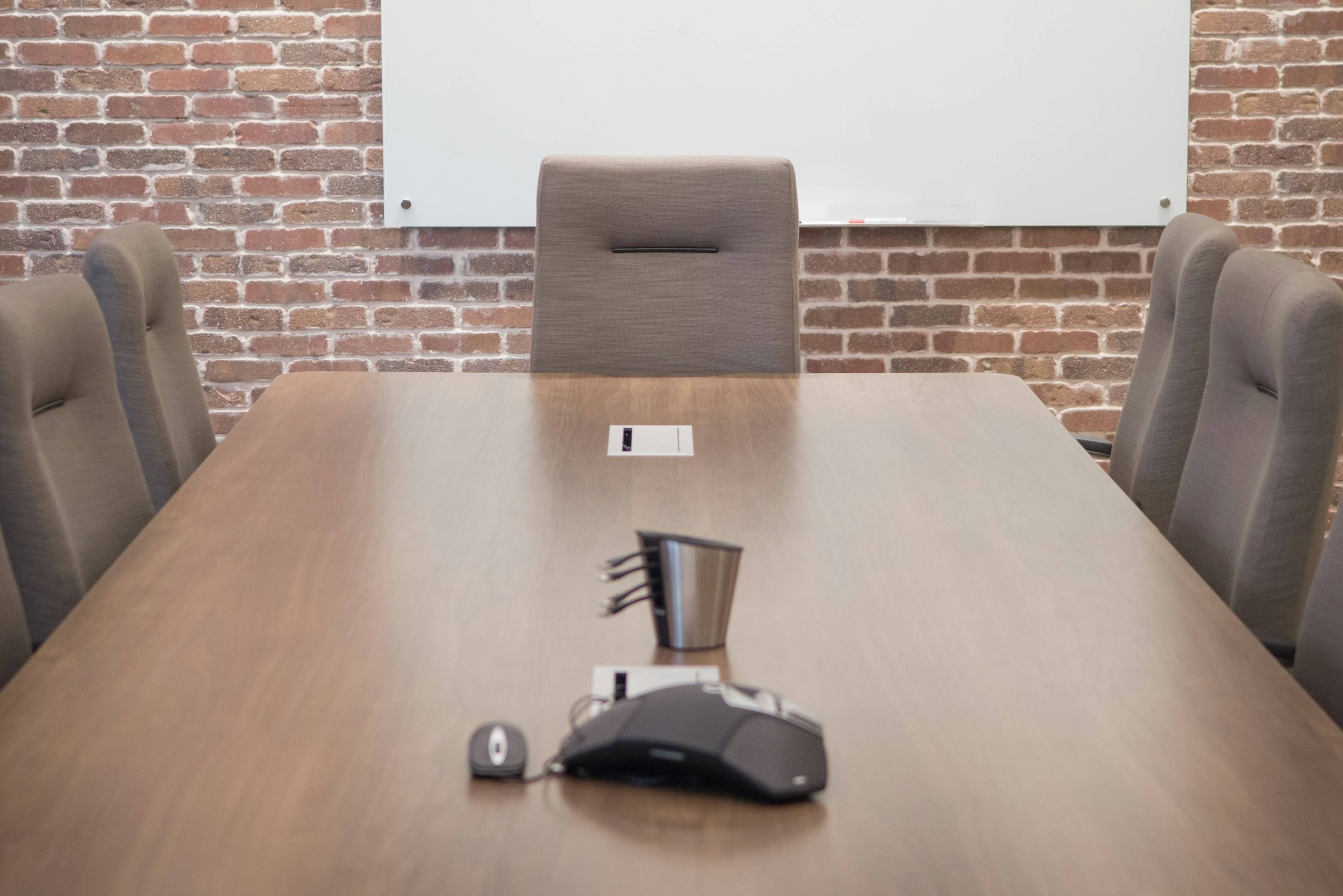 Conference table with empty seats around it.