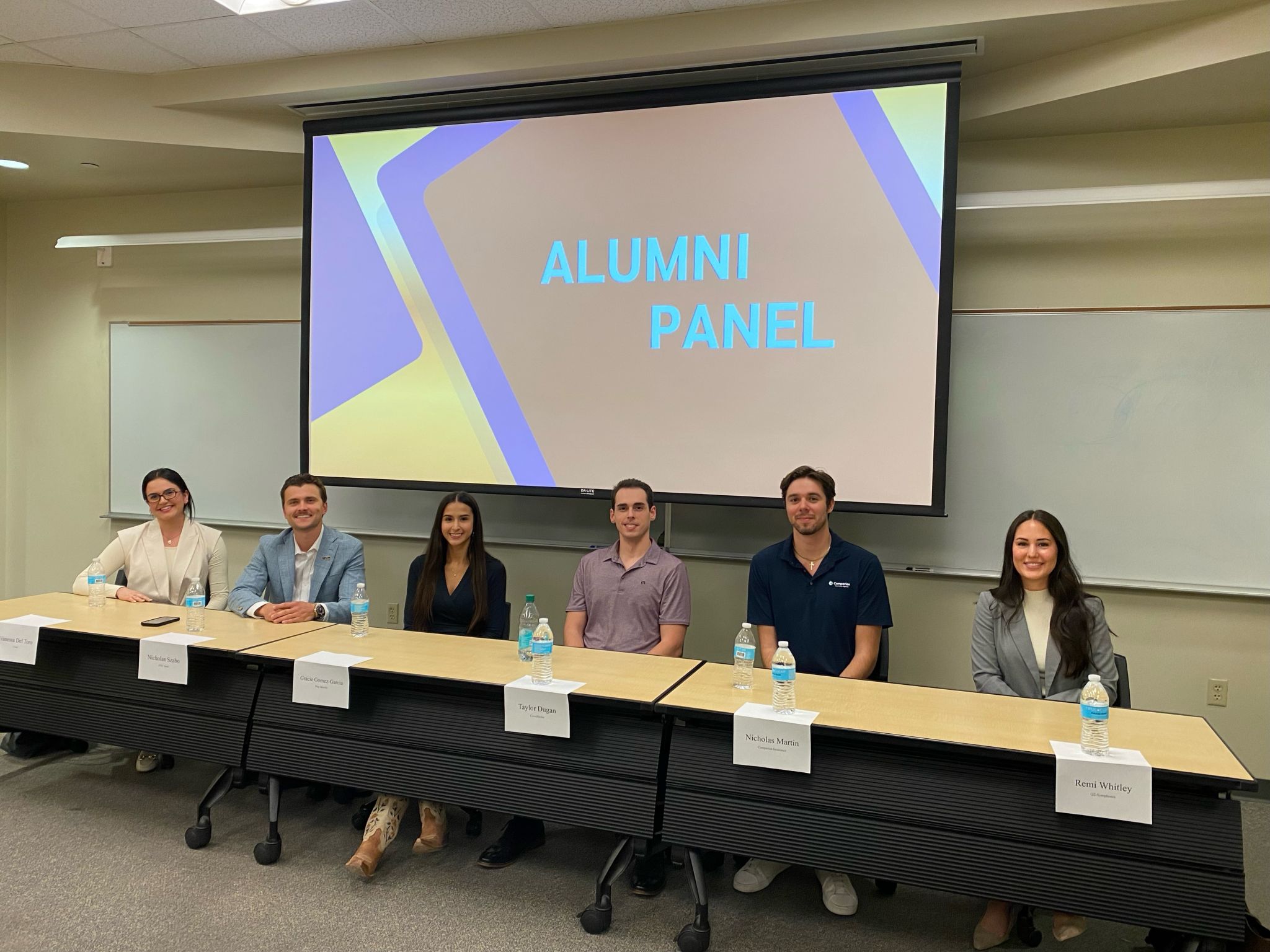 six sales alumni sitting at a table for a question panel