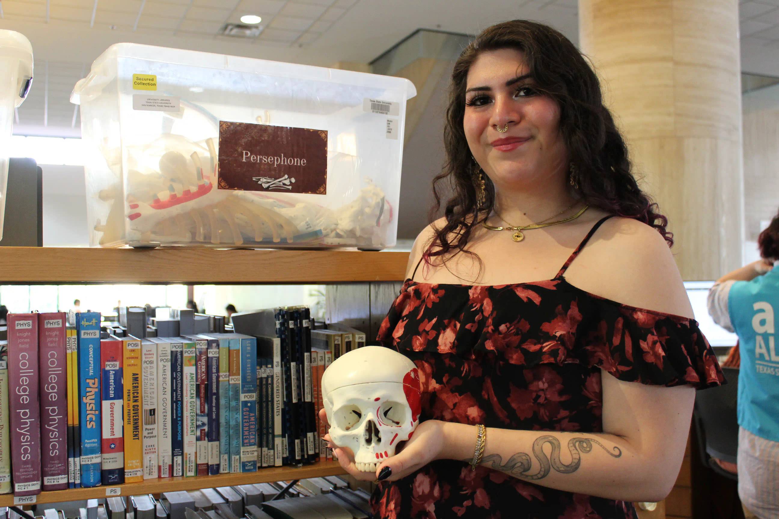 A female student holding a skeletal brain structure.