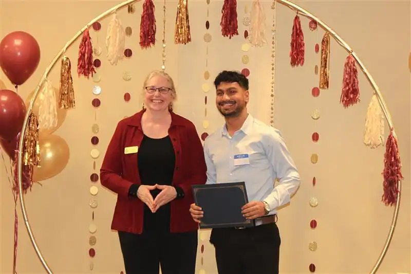 library directory handing out certificates to a third place winner team Rijal