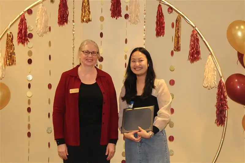 Library director handing out the certificate to the first place winner team Vo