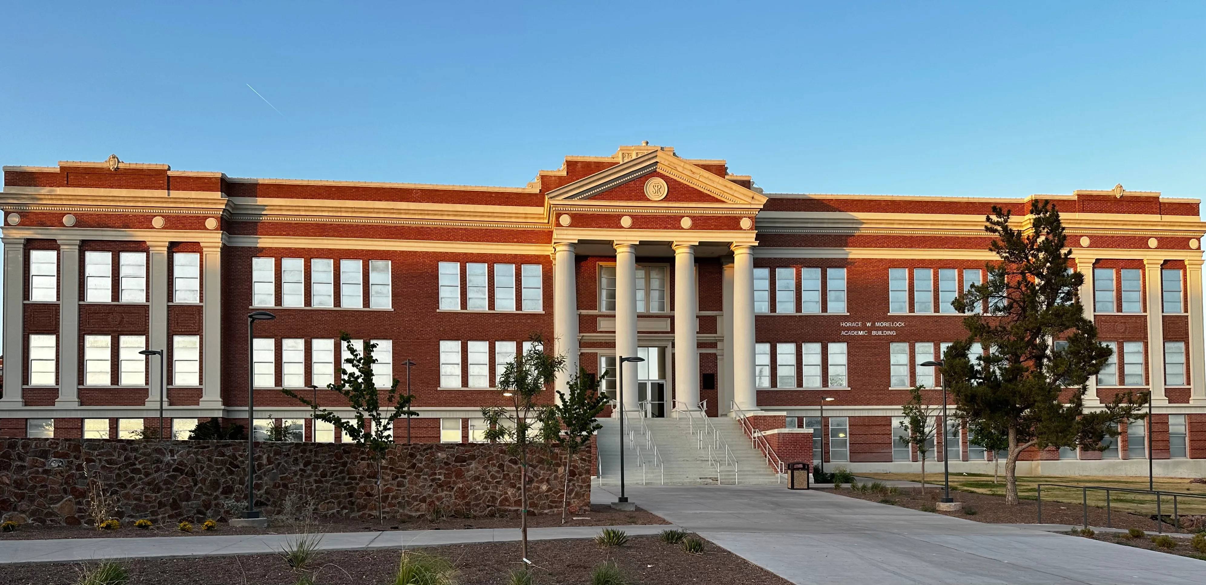 red brick building exterior featuring white pillars