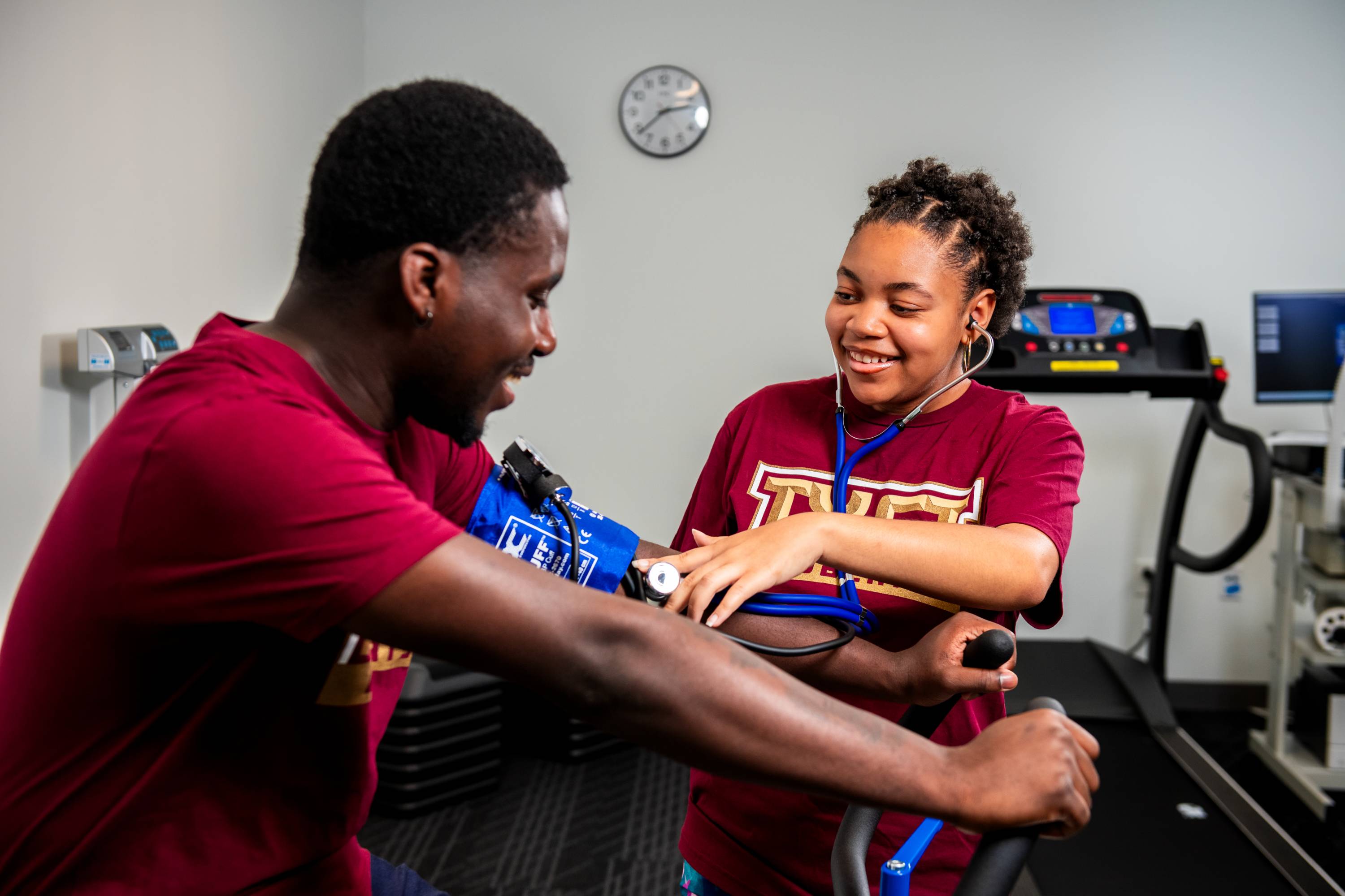 a student rides a stationary bike while having his vitals monitored