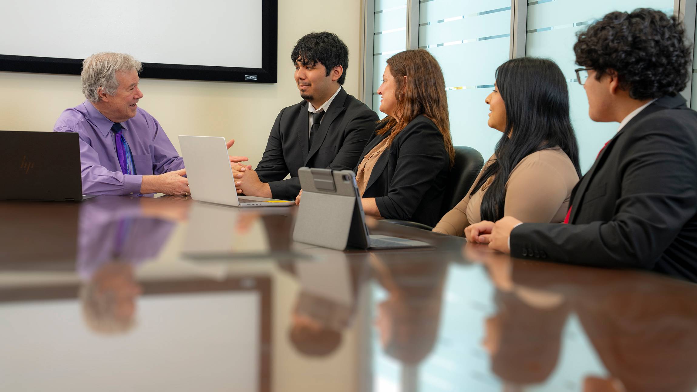 students sit at a conference room table