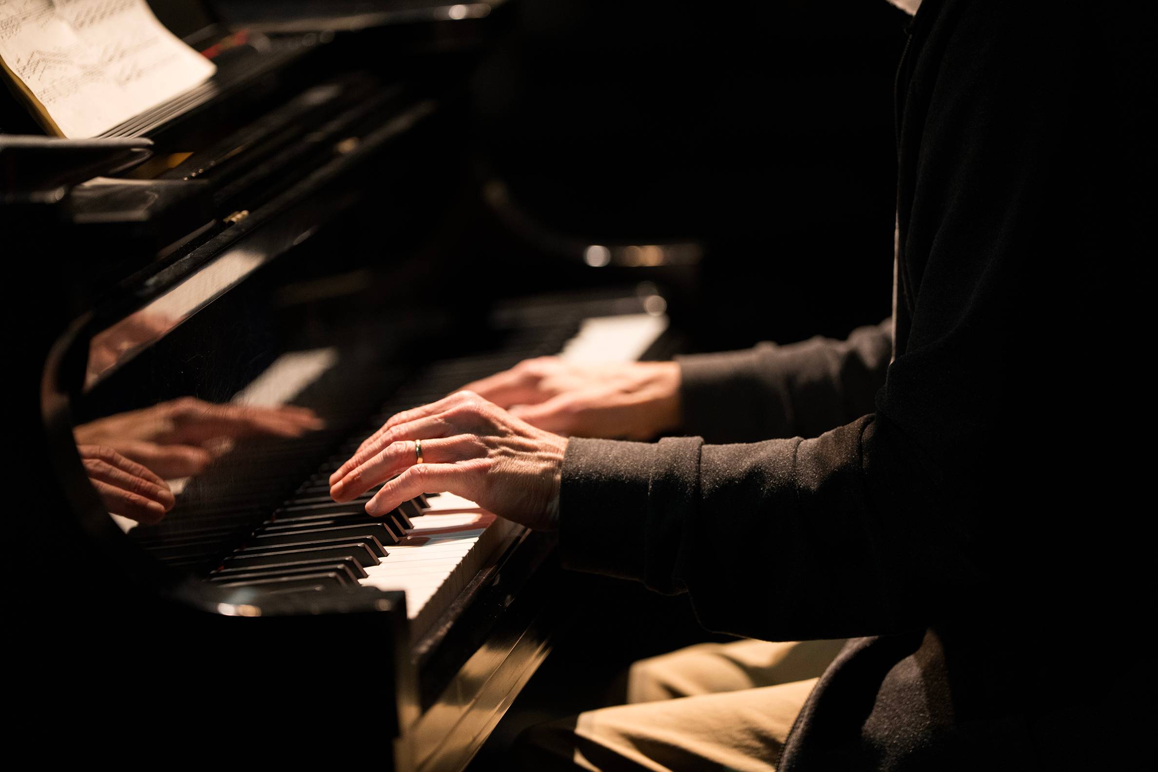 close up of man's hand playing a piano