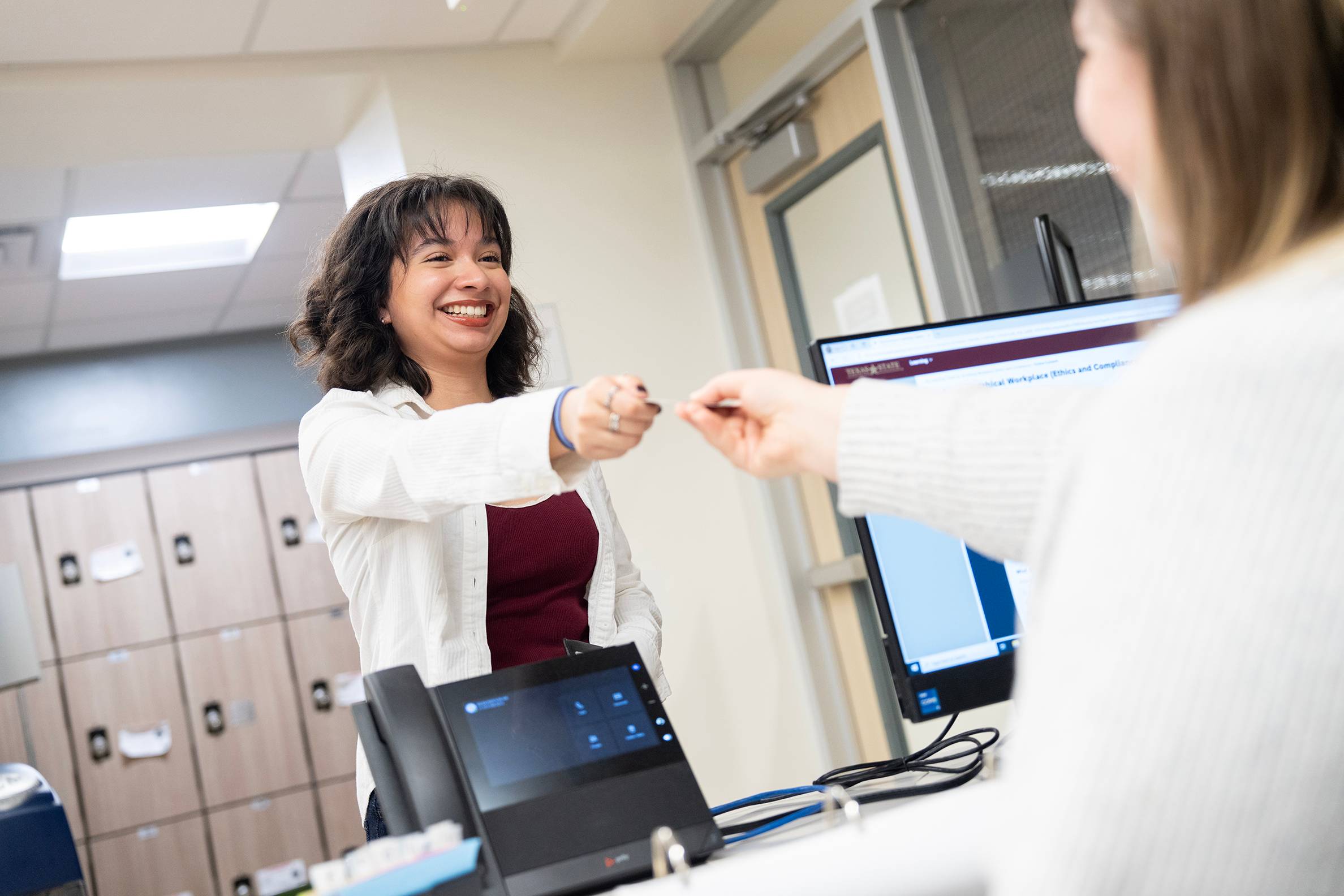 woman being handed object by another woman