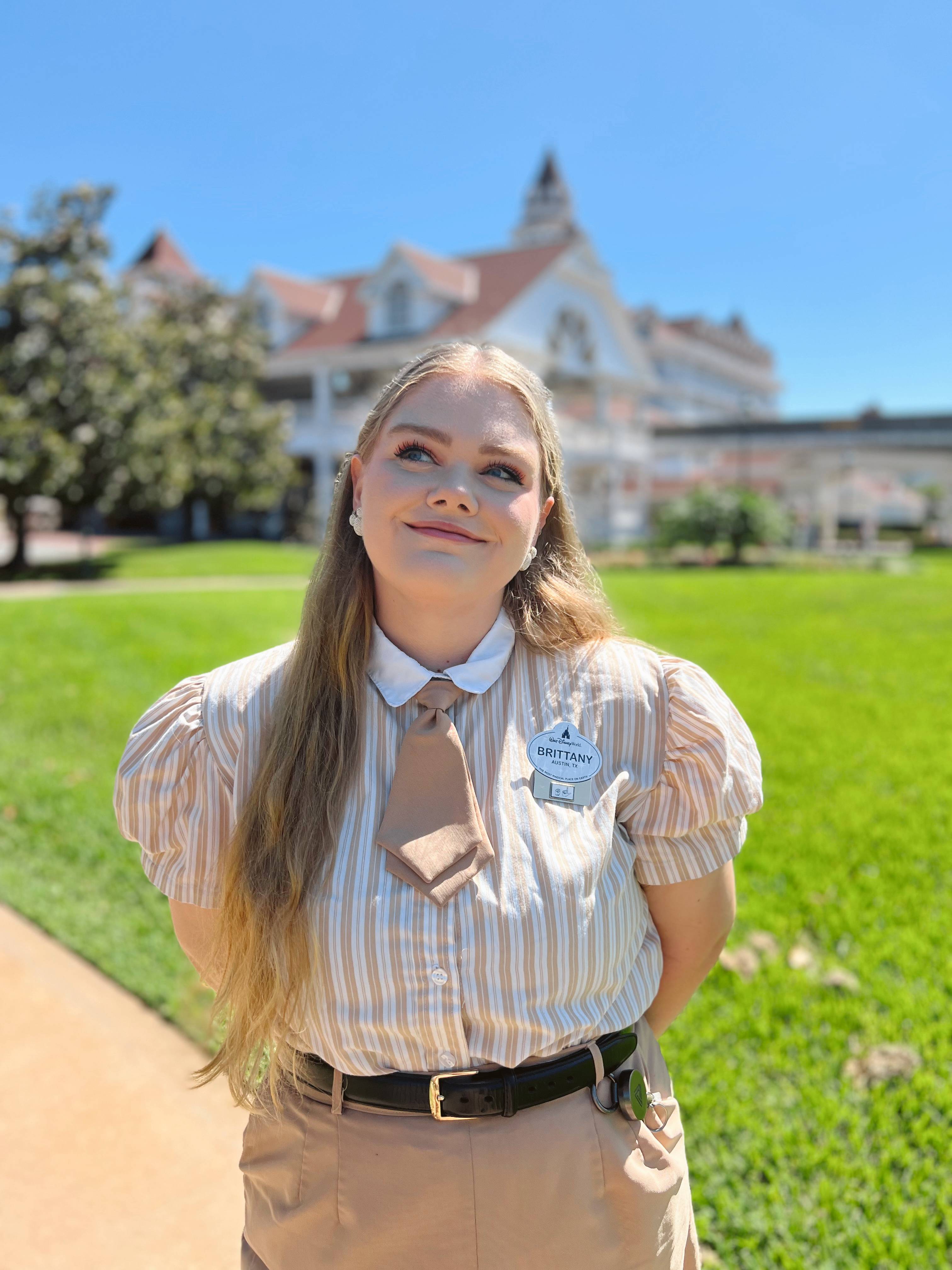 woman in walt disney uniform looks up towards sky