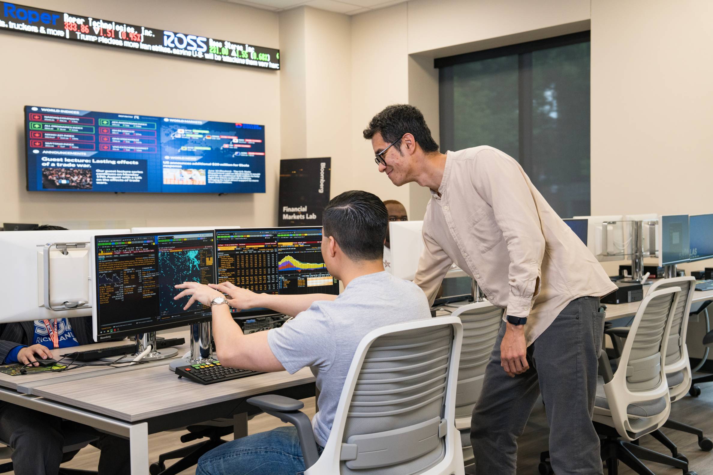 an instructor helps student on desktop