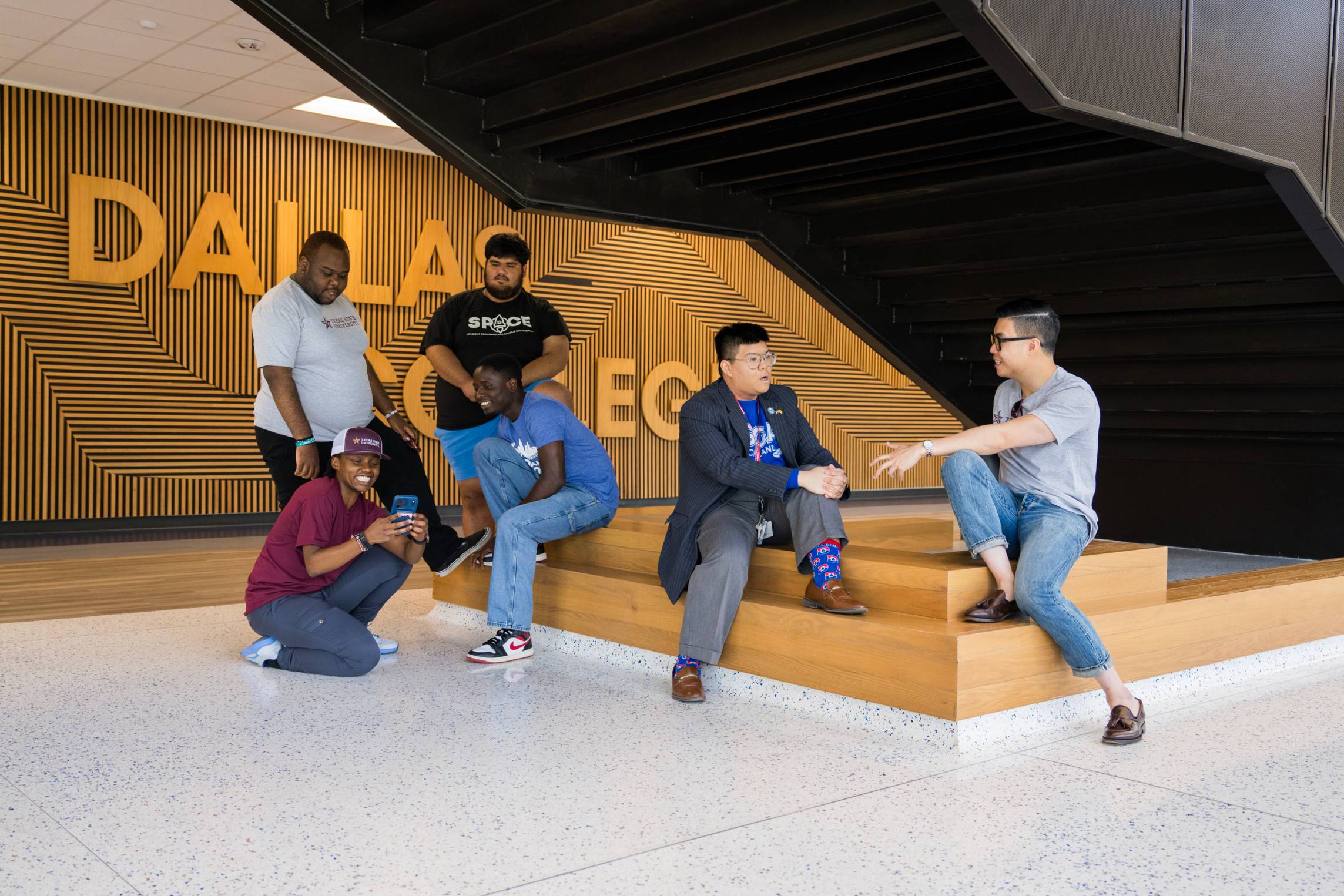 students laugh and share stories in a campus building