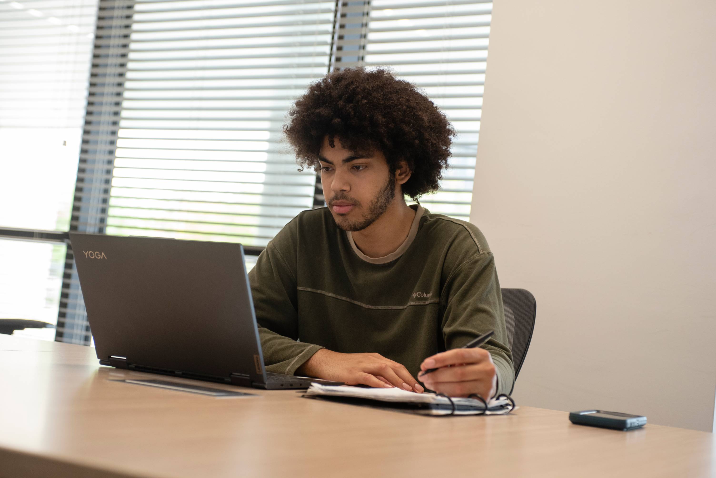 student looking at a computer taking notes