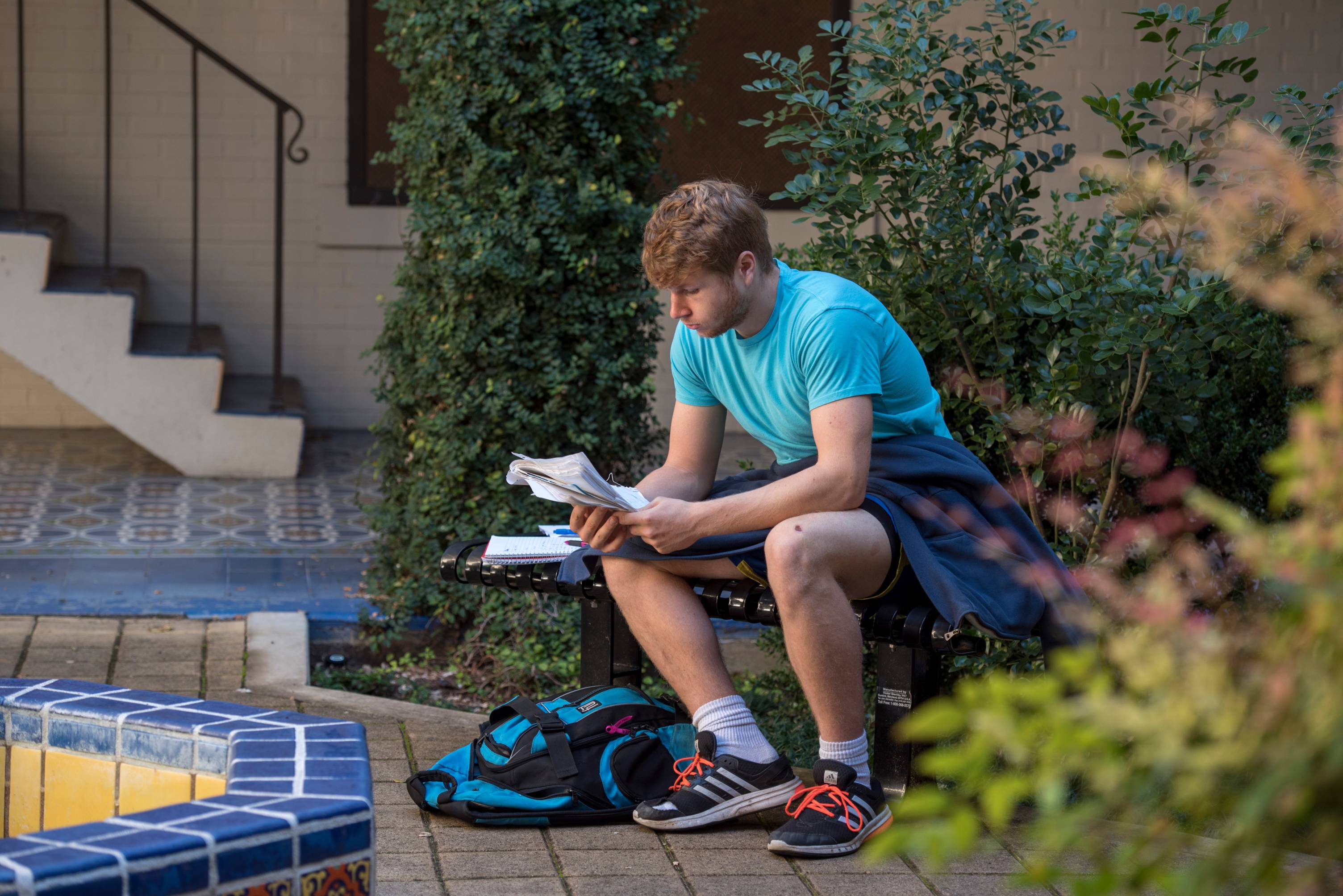 student reading a book outdoors